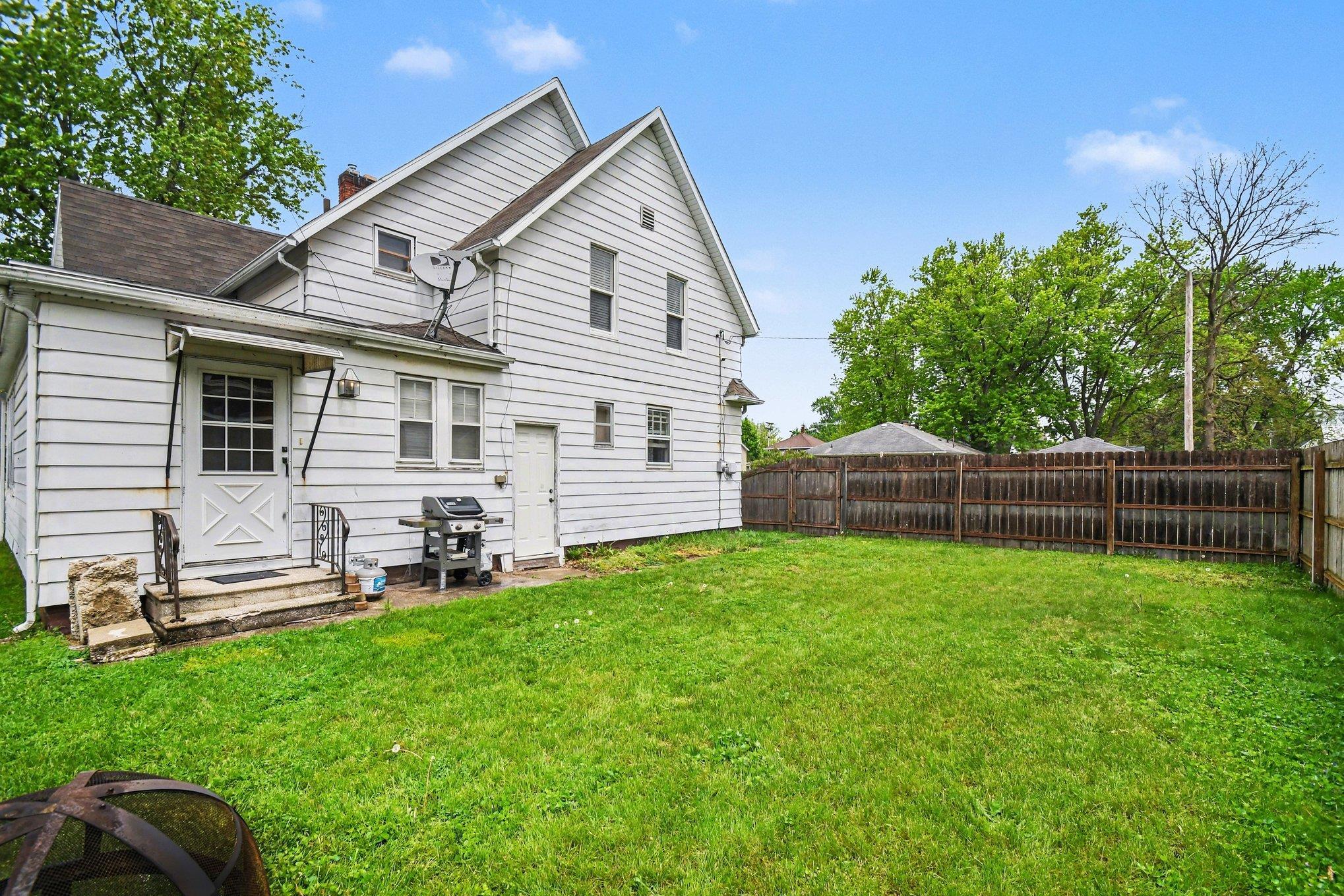 Expansive green lawn with a wood privacy fence