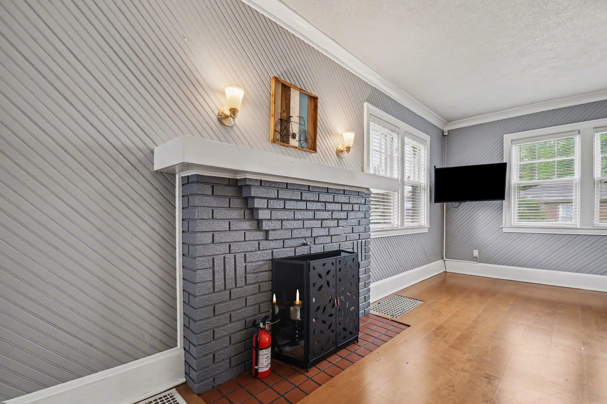 Fireplace featuring gray brick and a white mantel