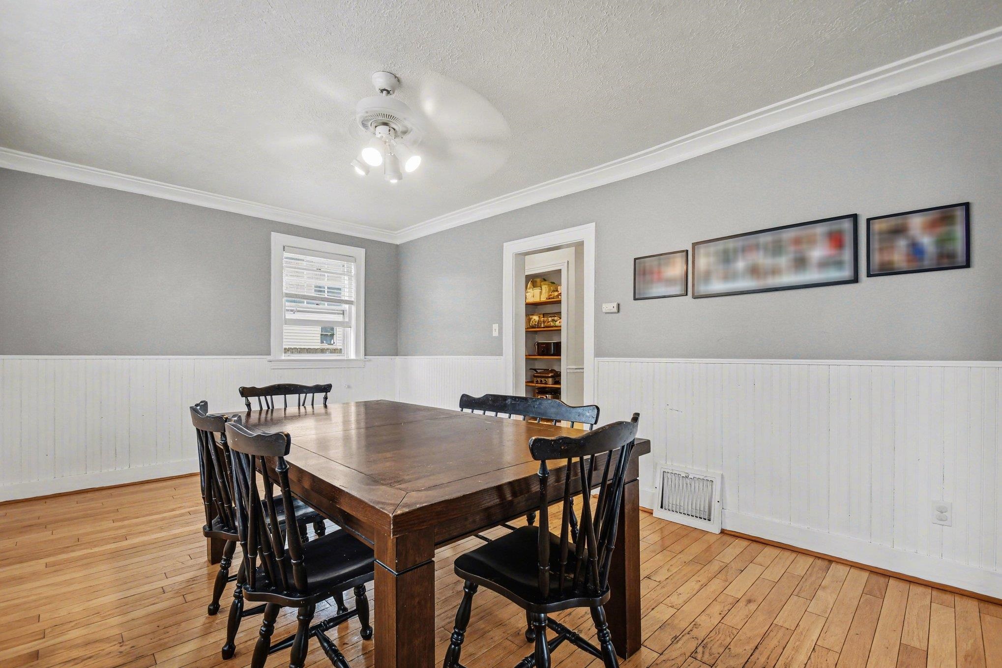 Hardwood flooring throughout, featuring white wainscoting and light gray walls