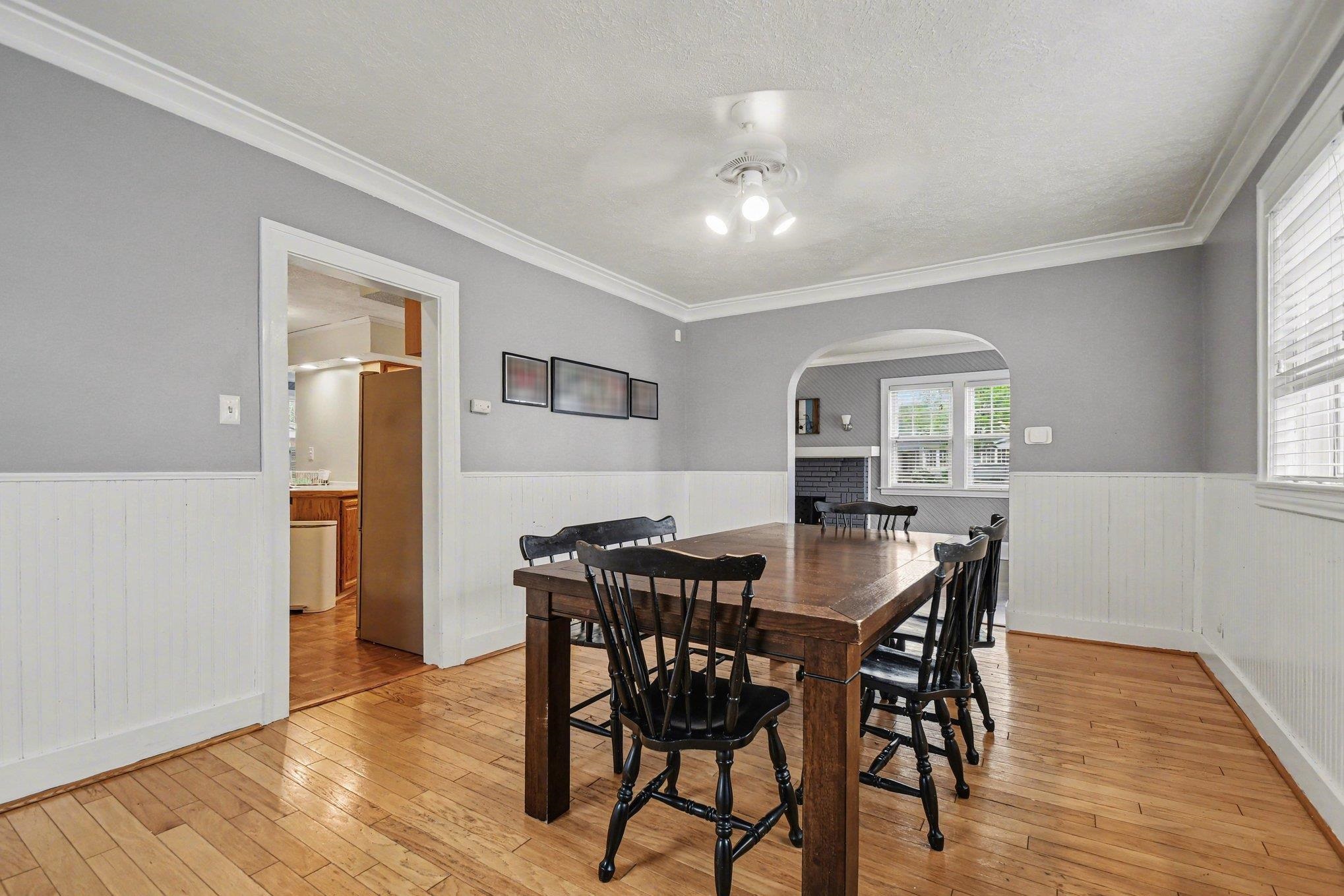 Hardwood flooring throughout the room with white wainscoting and light gray walls