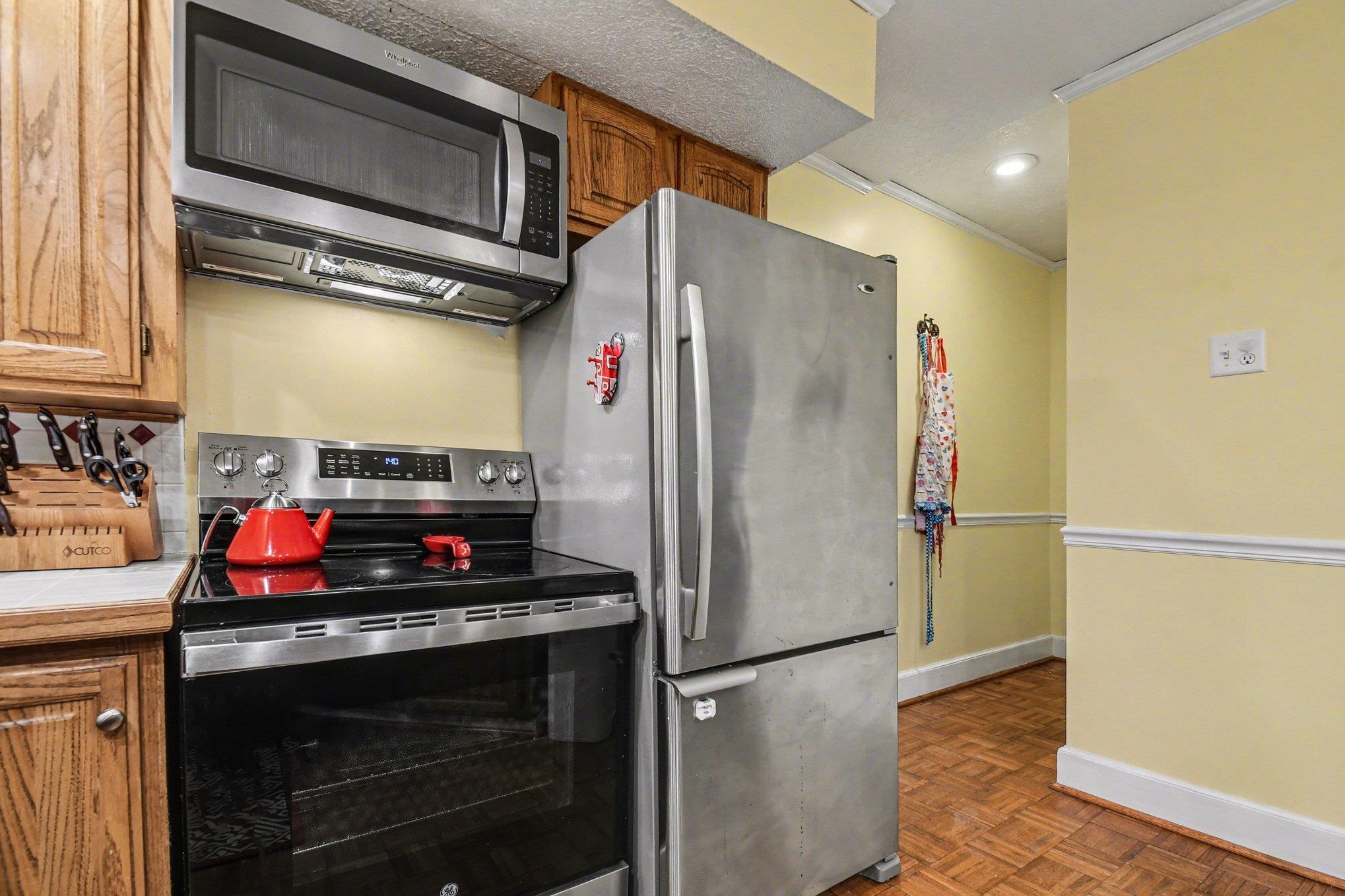 Kitchen featuring wood cabinetry, stainless steel appliances, and wood-finish flooring
