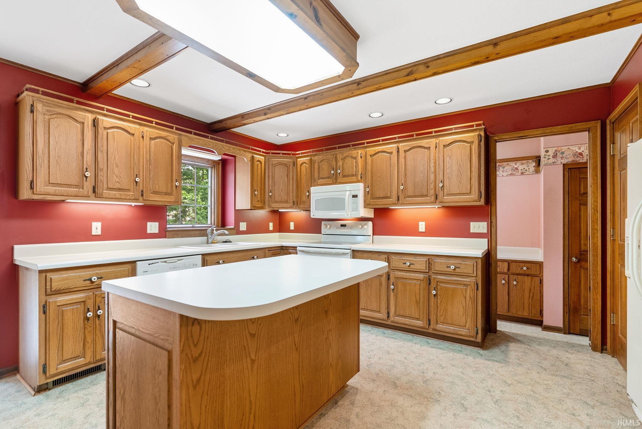 Kitchen featuring extensive wood cabinetry, white countertops, a central island, recessed lighting, and a built-in microwave