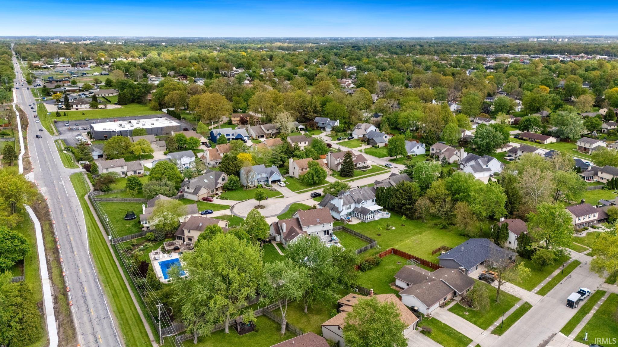 Residential neighborhood featuring mature trees, paved streets, and sidewalks