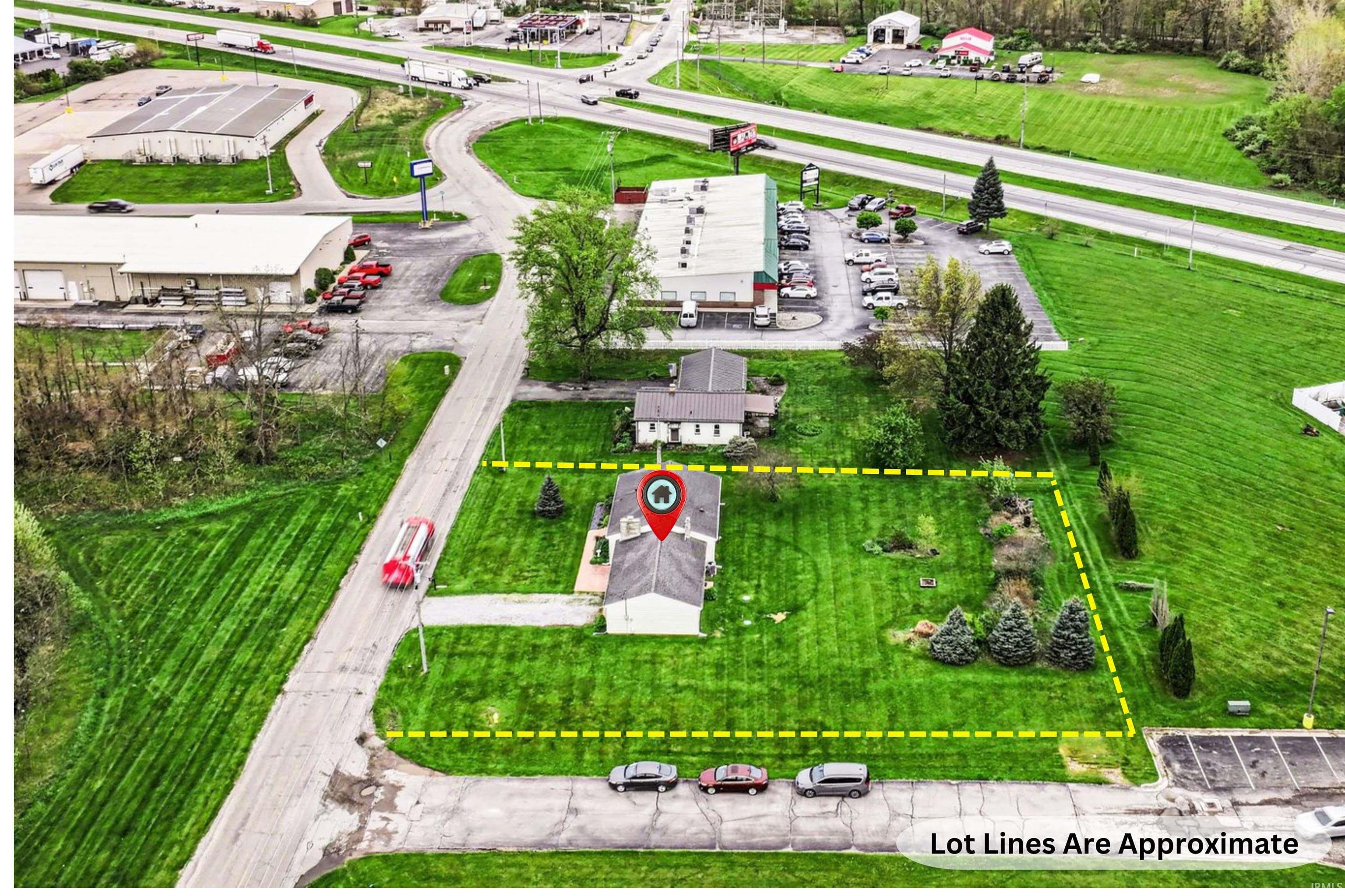 Expansive lot featuring a single-story structure and surrounding green space with mature trees