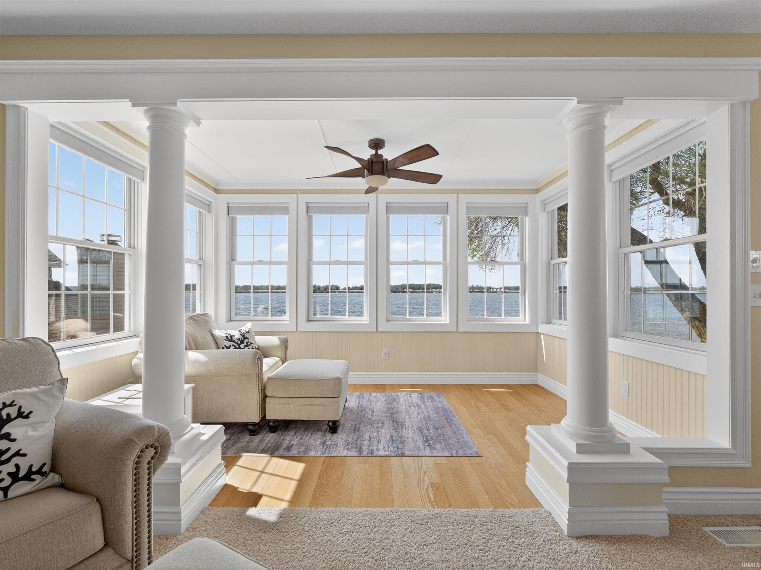 Sunroom / solarium featuring decorative columns and wood finished floors