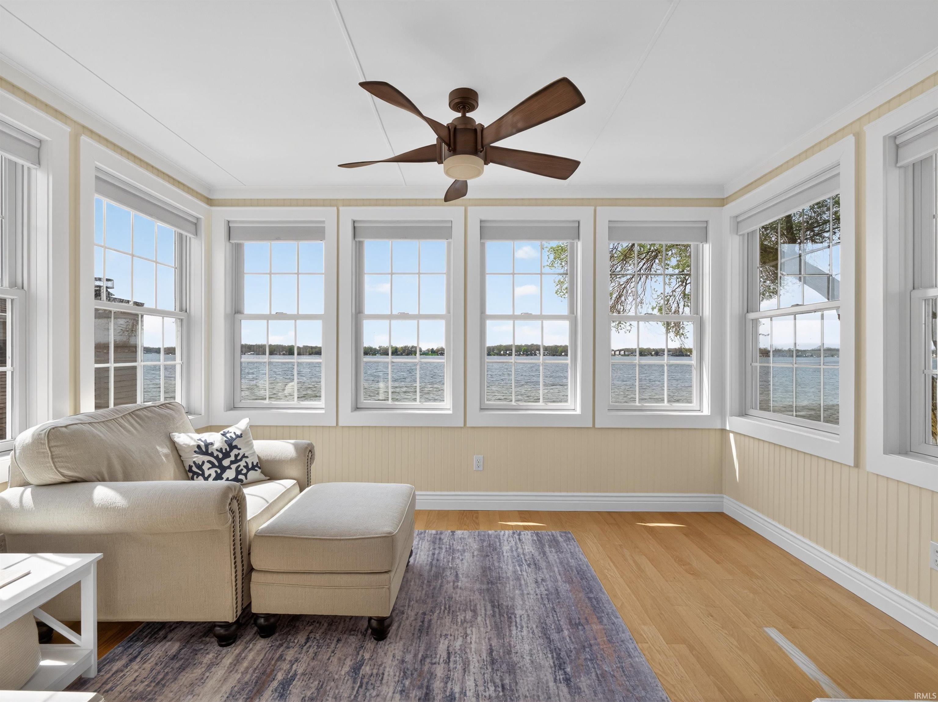 Sunroom with wood finished floors and a water view