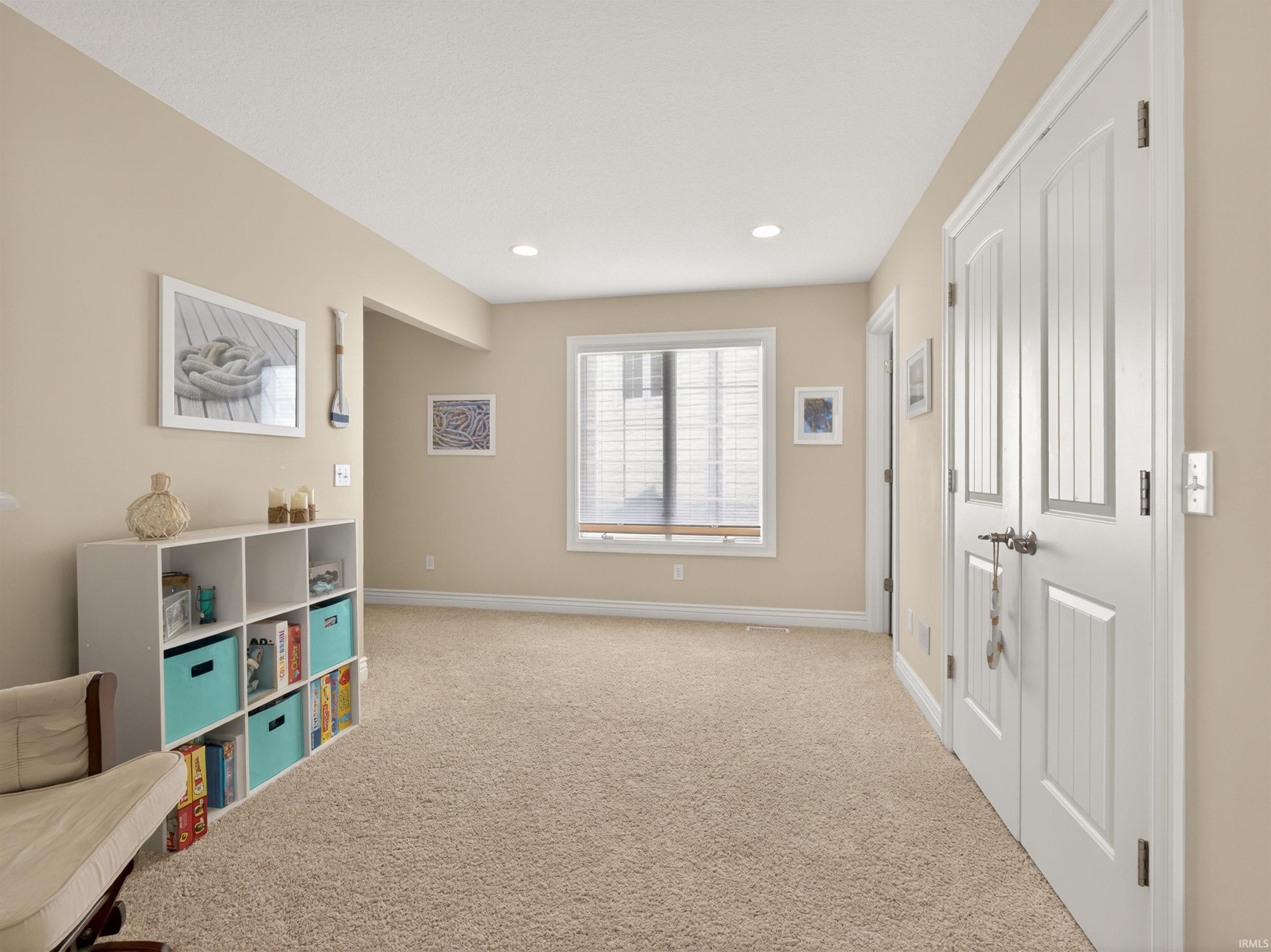 Sitting room with light colored carpet and recessed lighting