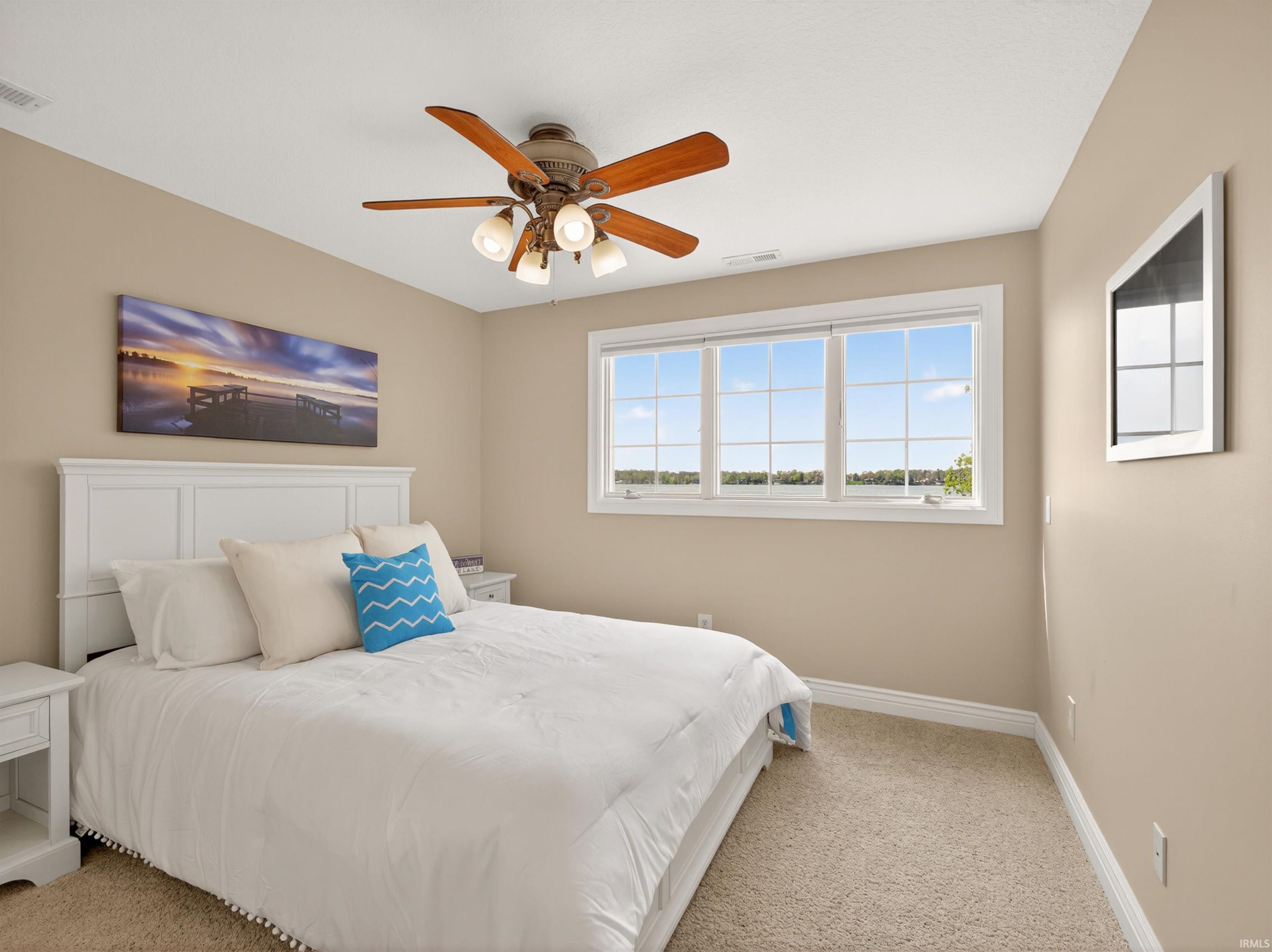 Bedroom with light colored carpet and ceiling fan