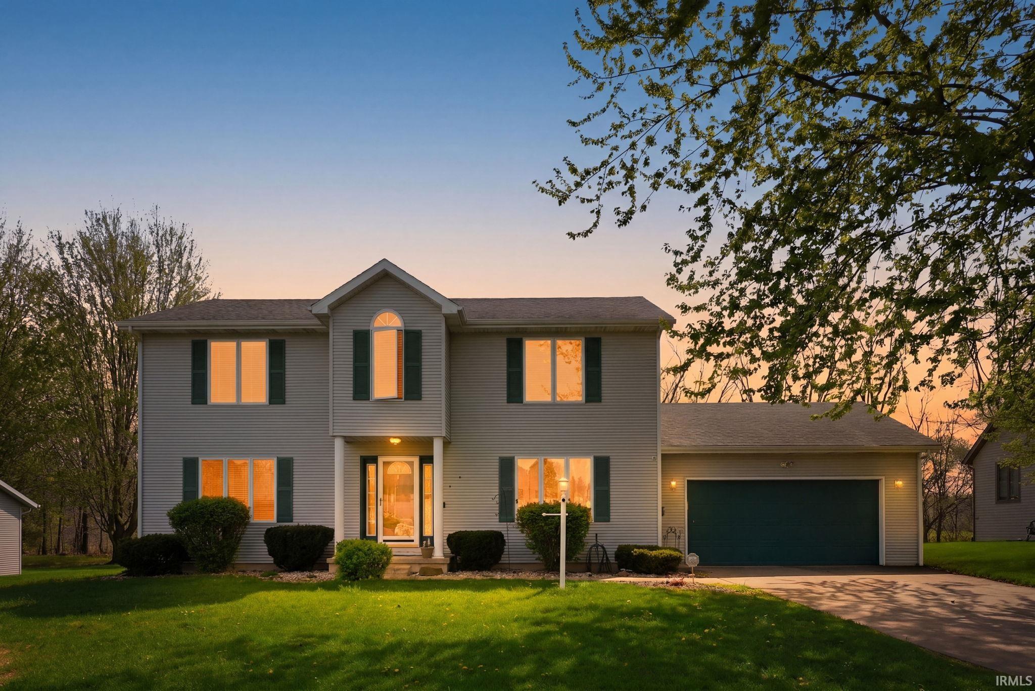 Two-story residence featuring light gray siding with dark green shutters