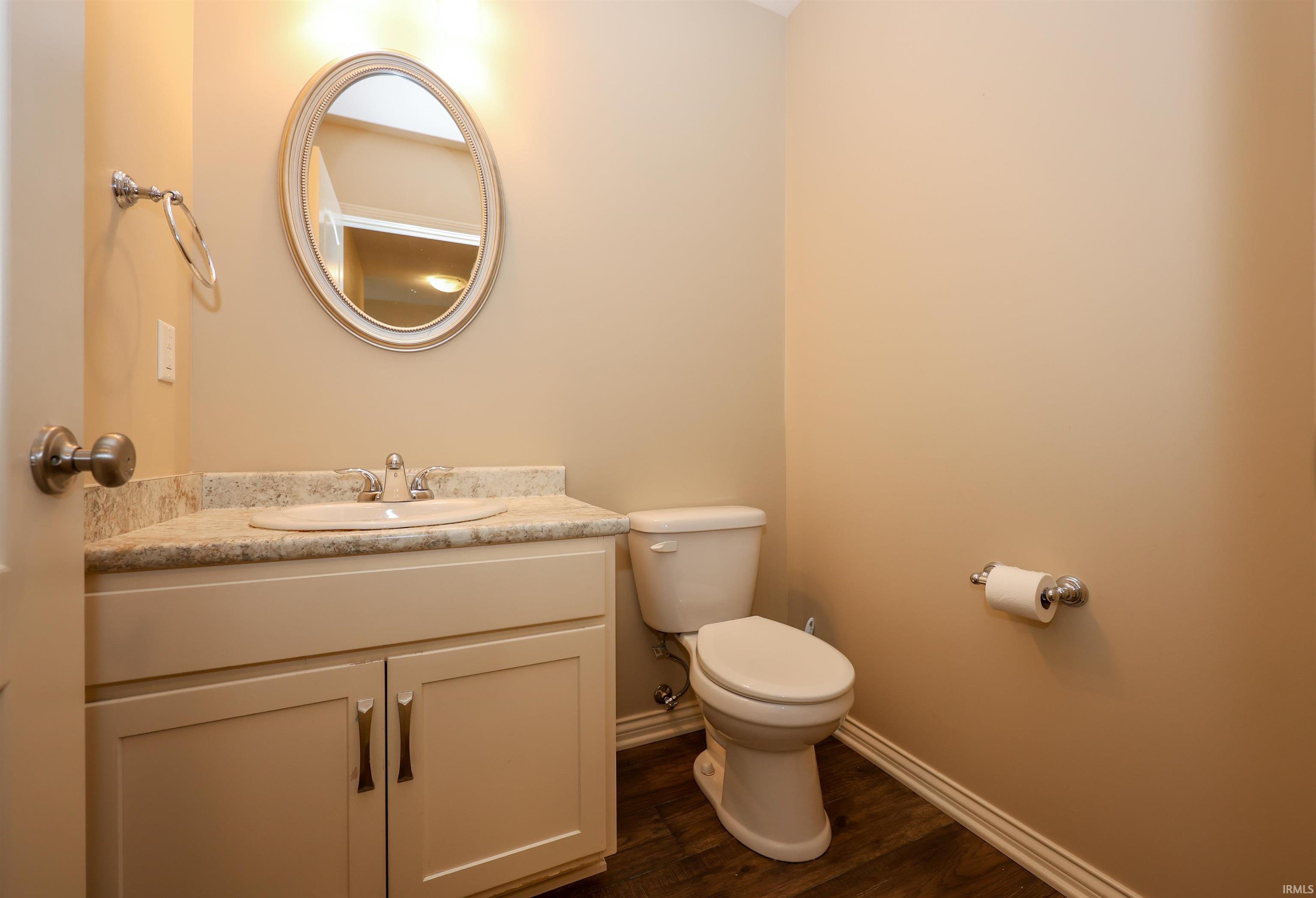 Bathroom vanity with an integrated sink, granite-style countertop, and white cabinetry featuring brushed nickel hardware