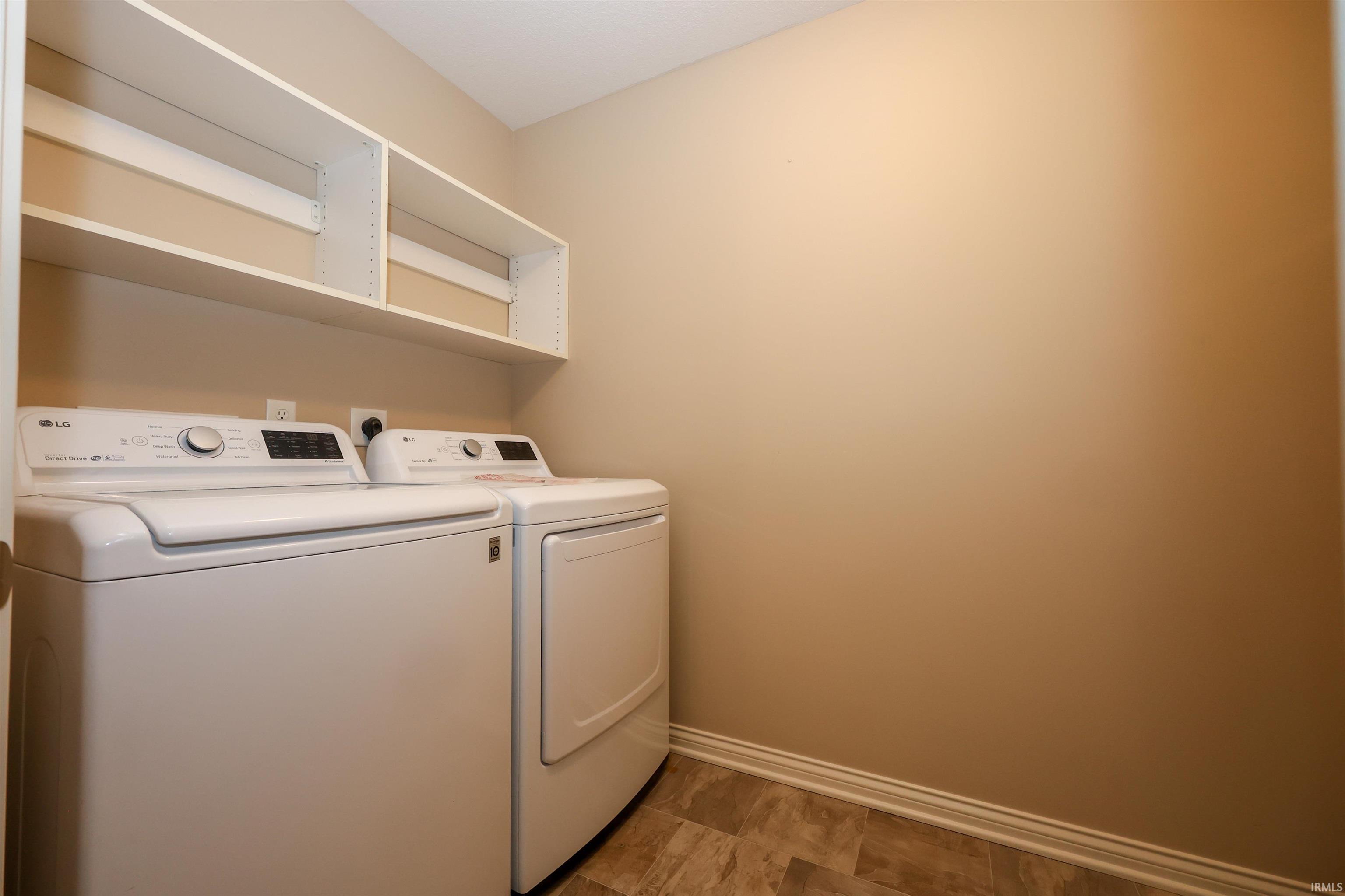 Dedicated laundry area featuring overhead shelving, wood-finish flooring, and neutral wall tones