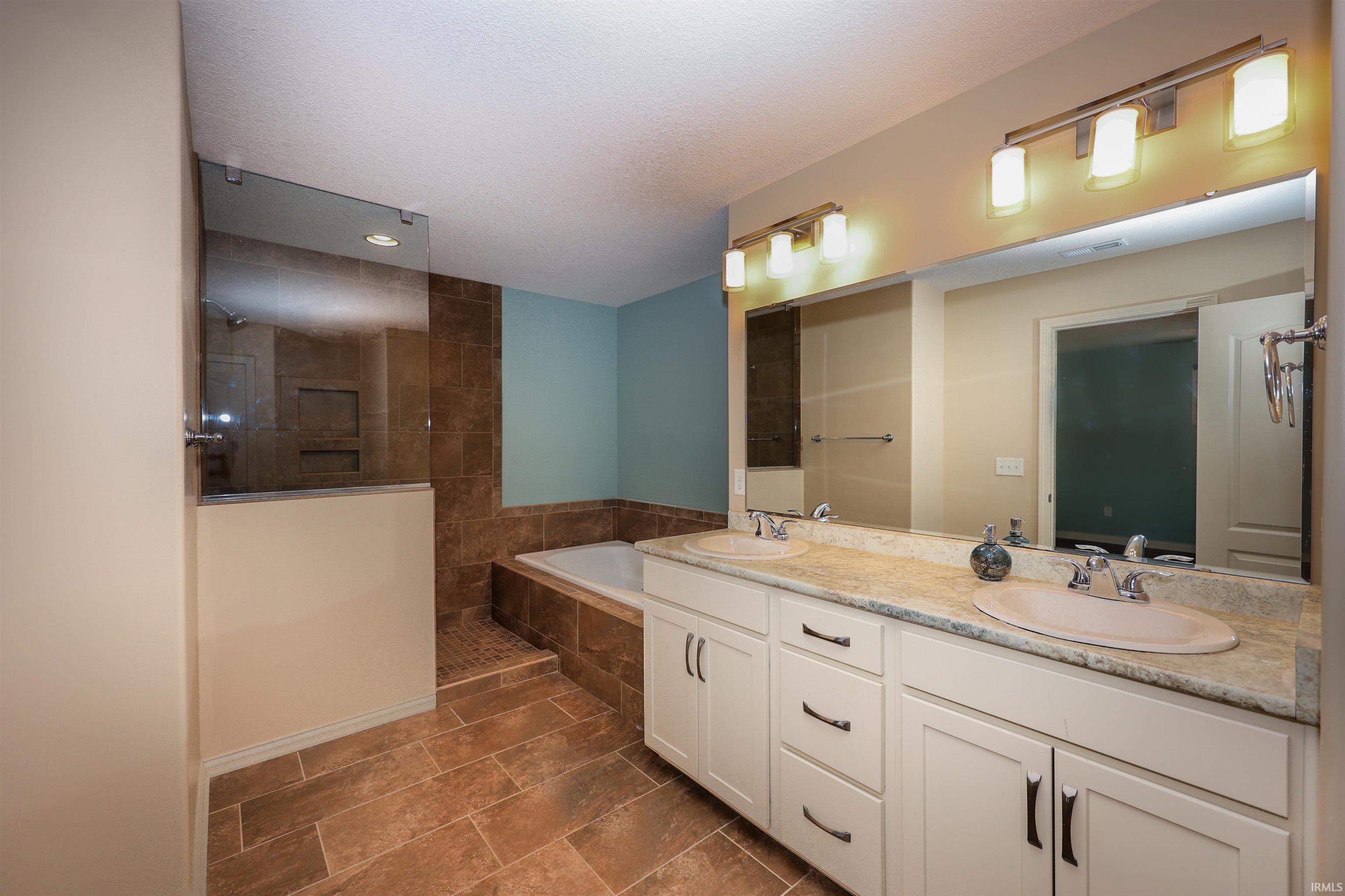 Double vanity with light-toned countertops and undermount sinks