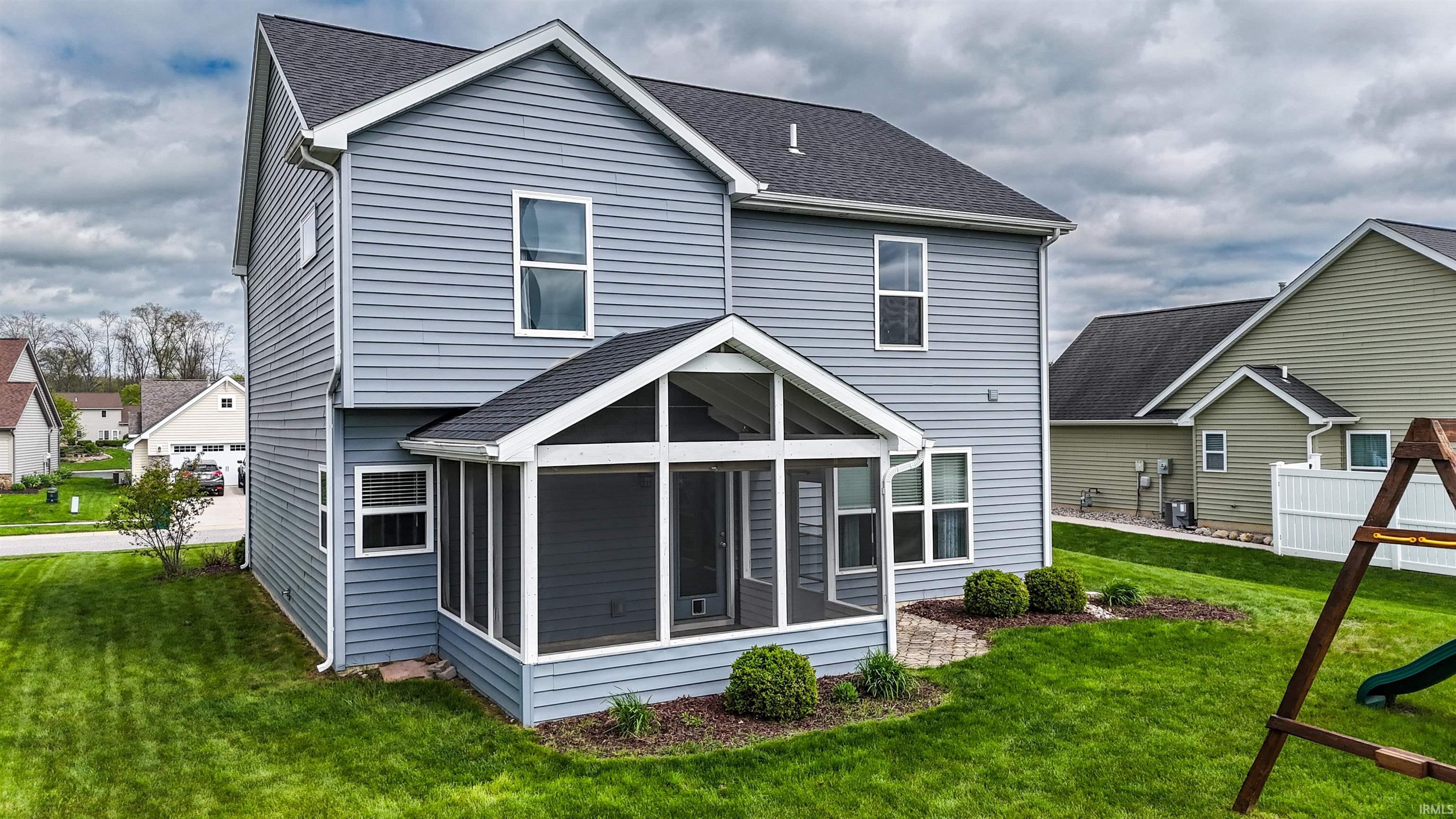 Rear exterior with gray horizontal siding and a screened-in porch