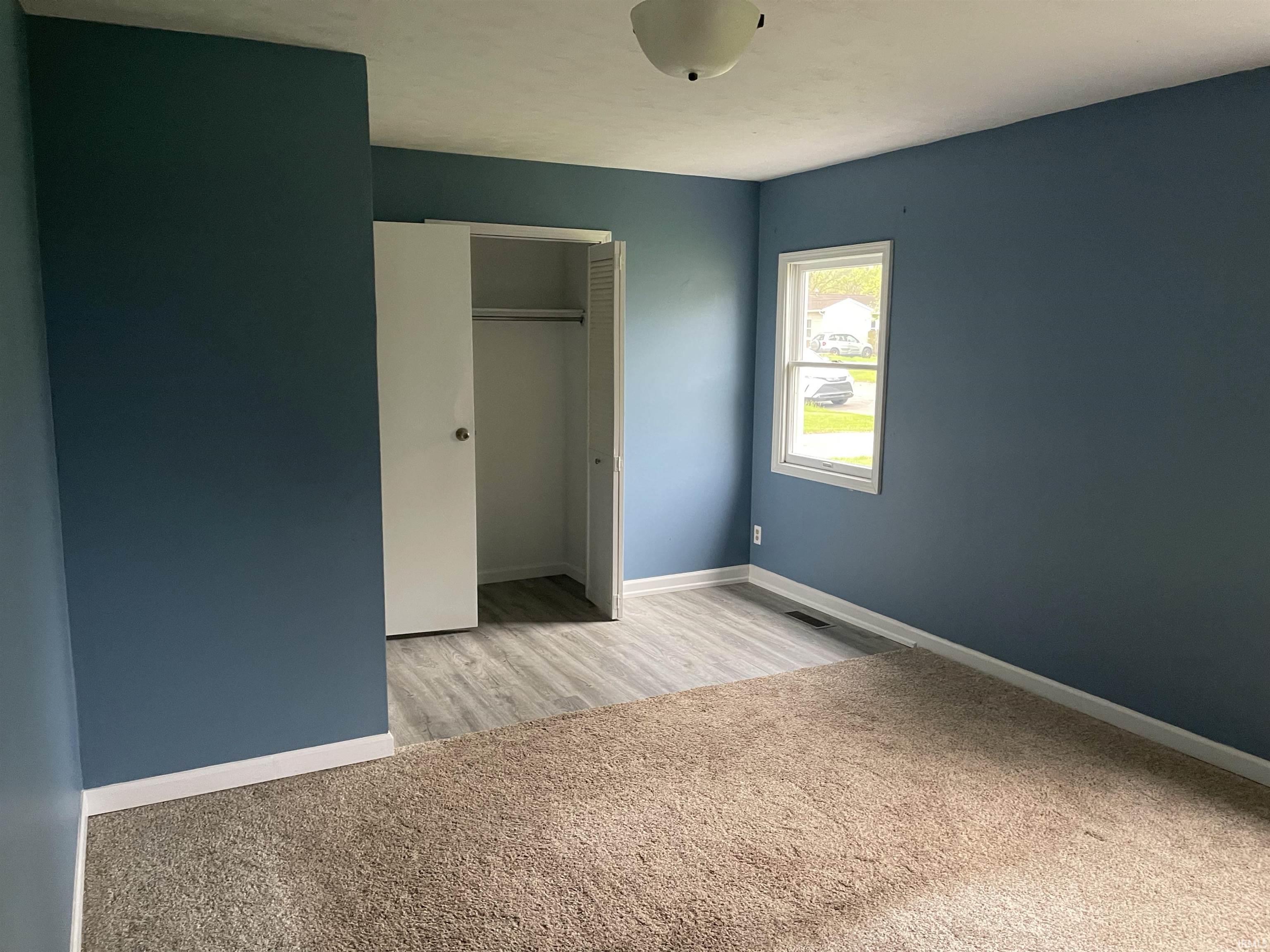 Bedroom featuring blue-painted walls and a ceiling-mounted light fixture