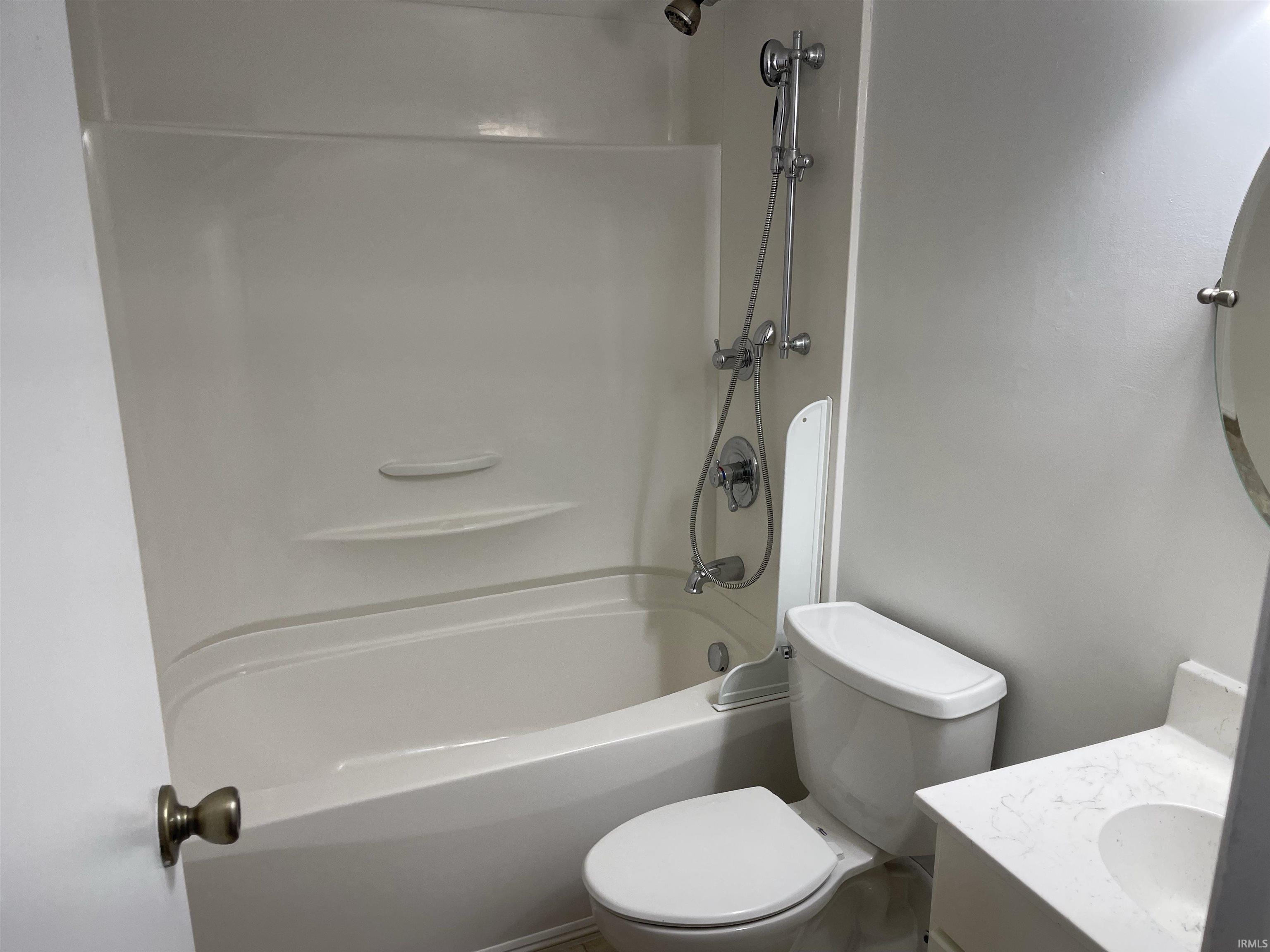 White fiberglass tub and shower combination with chrome fixtures