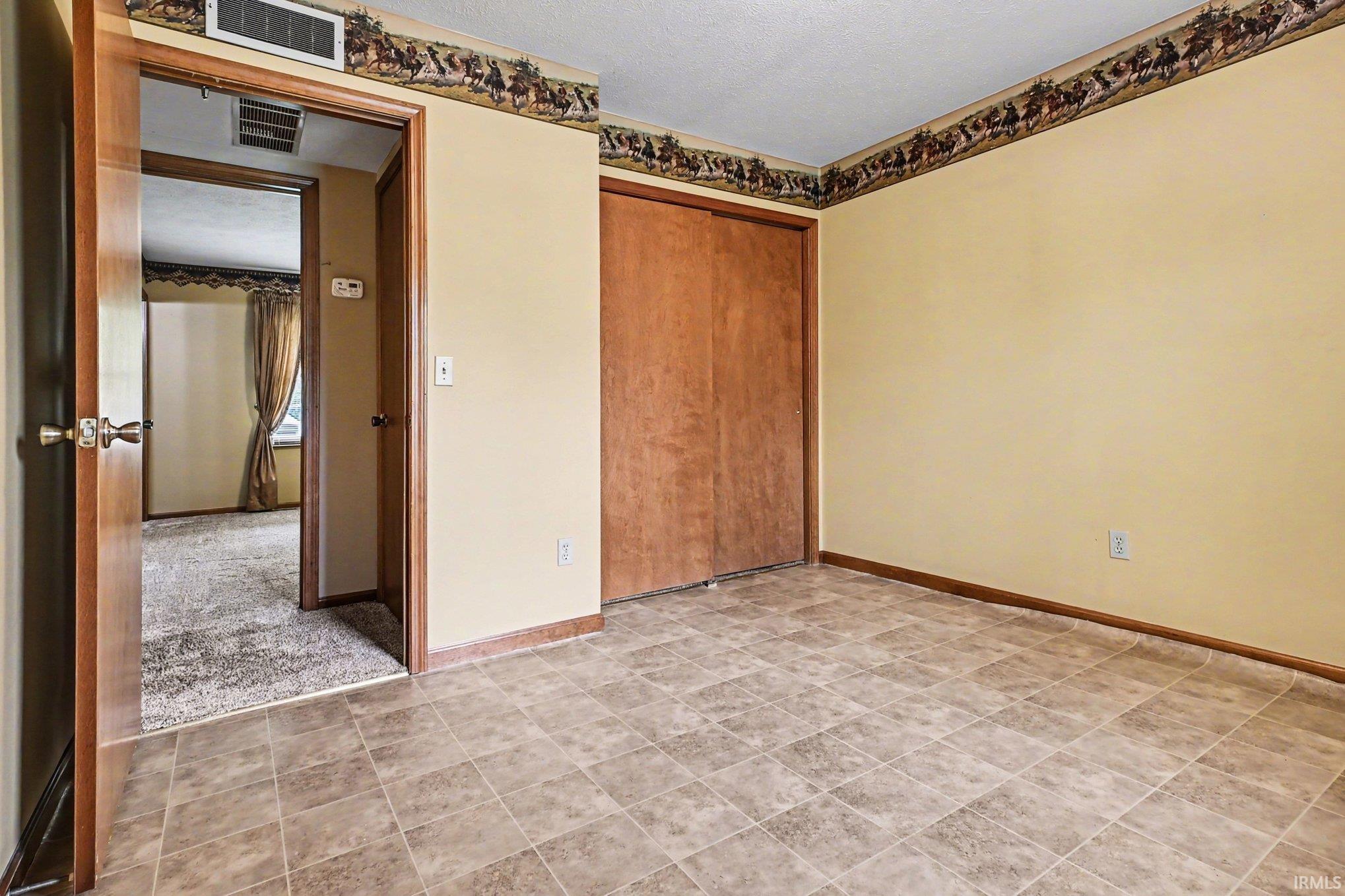 Neutral-toned tiled flooring complemented by light cream walls and dark wood-finish trim