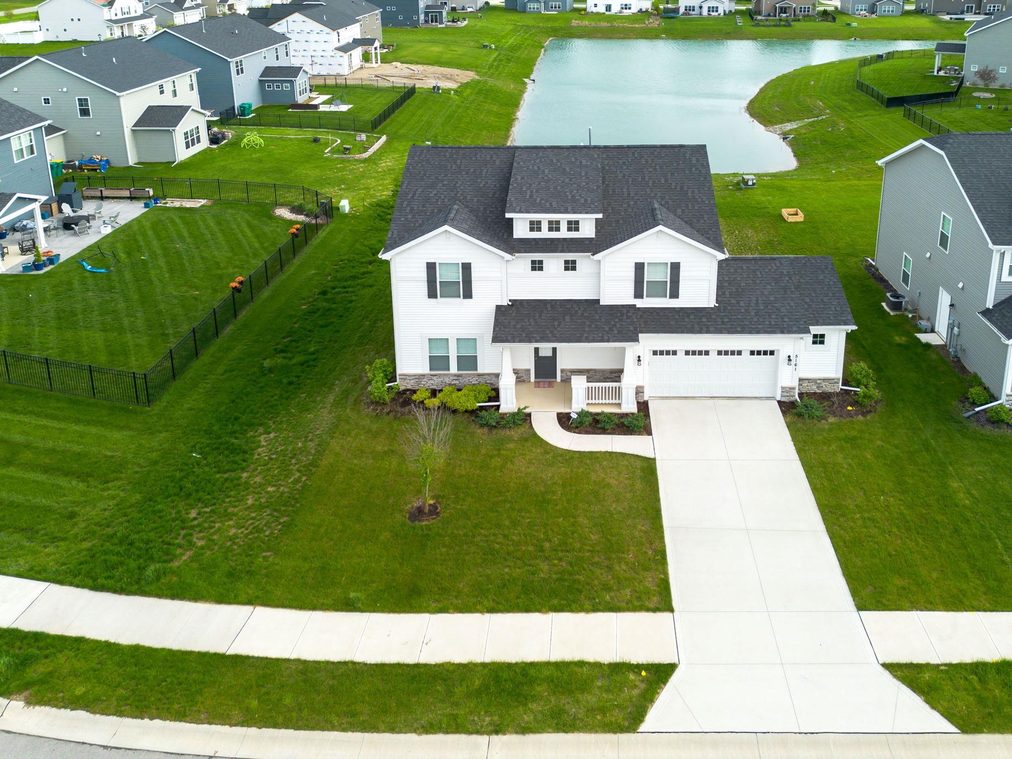 Contemporary two-story residence with a dark shingled roof and white siding
