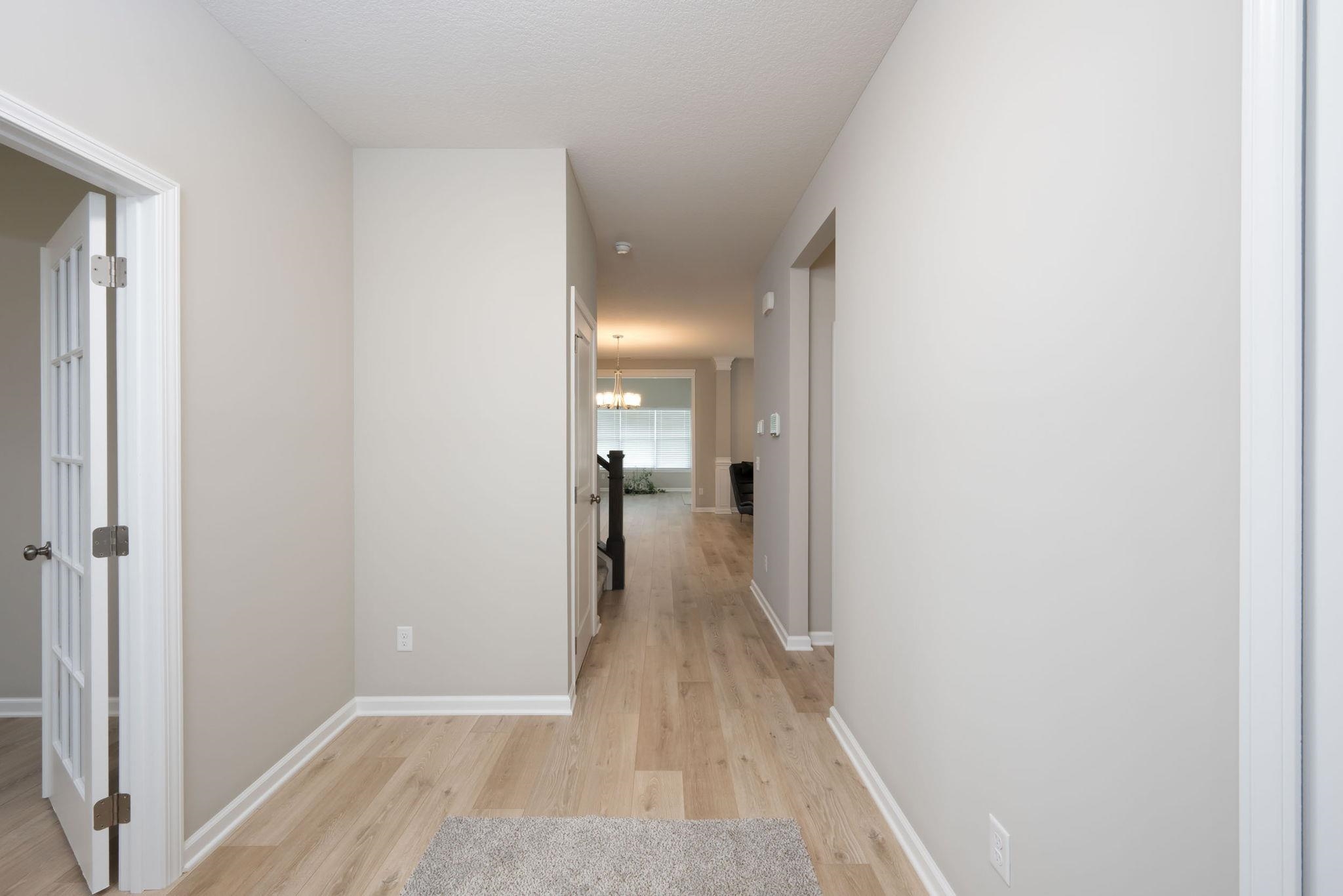 Hallway featuring light wood-finish flooring and neutral wall tones