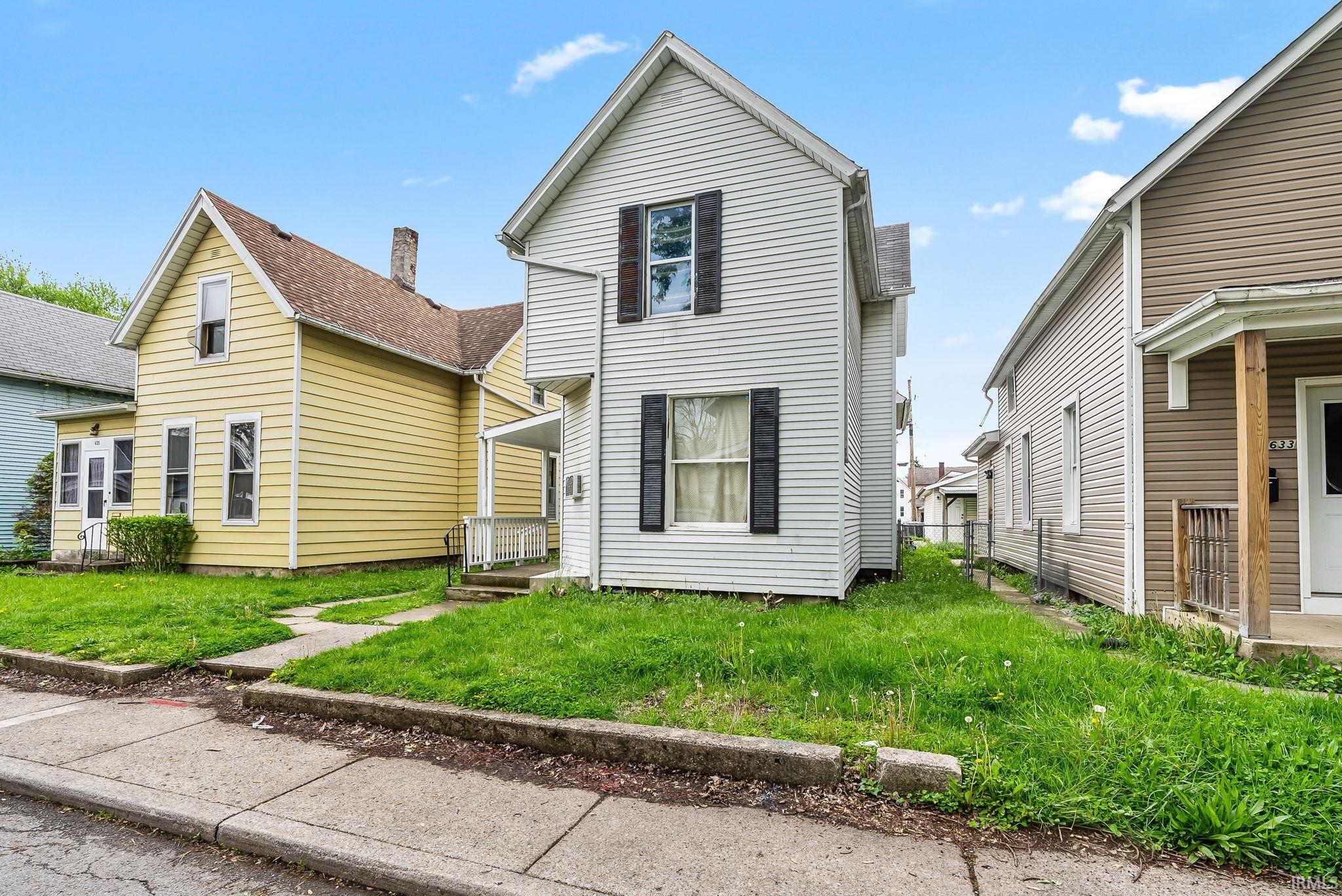 Traditional two-story home with white siding, black window shutters, and a covered front porch