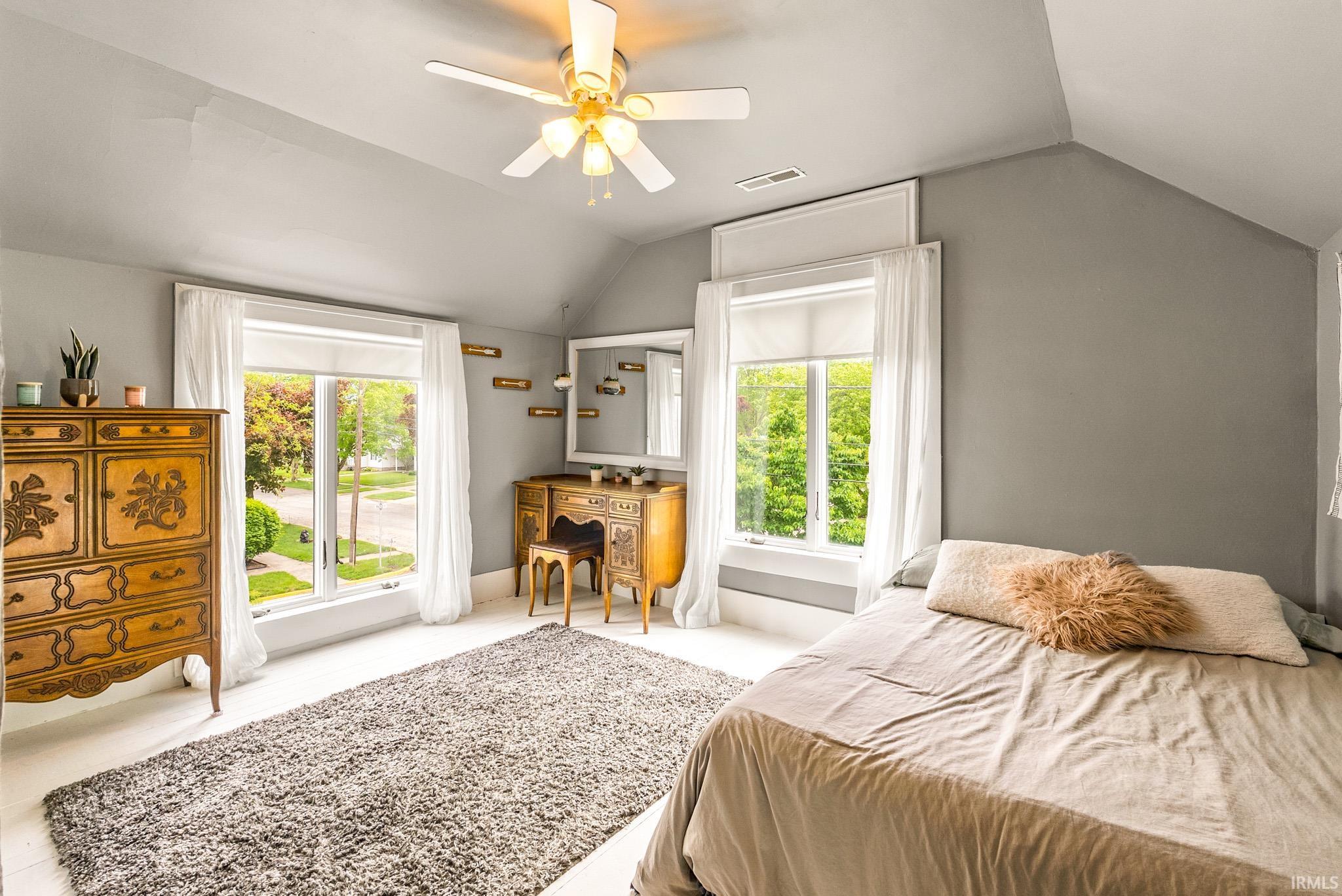 Vaulted ceiling bedroom with white-painted wood-finish flooring