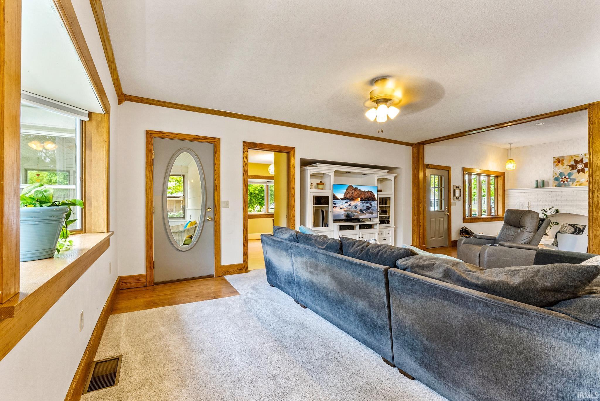 Living area featuring light-colored carpeting and wood-finish flooring