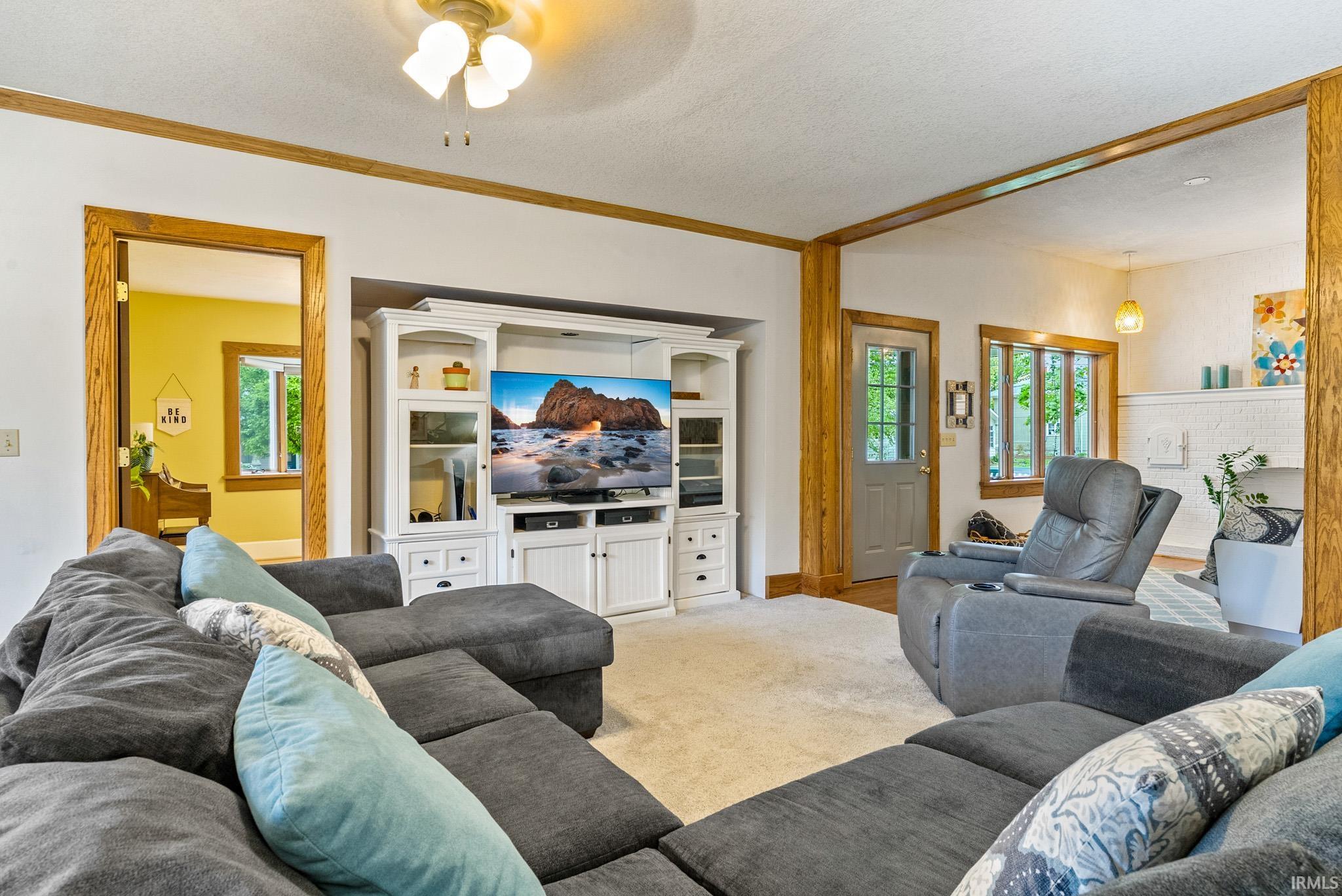Living area with wood-finish trim and neutral carpeting
