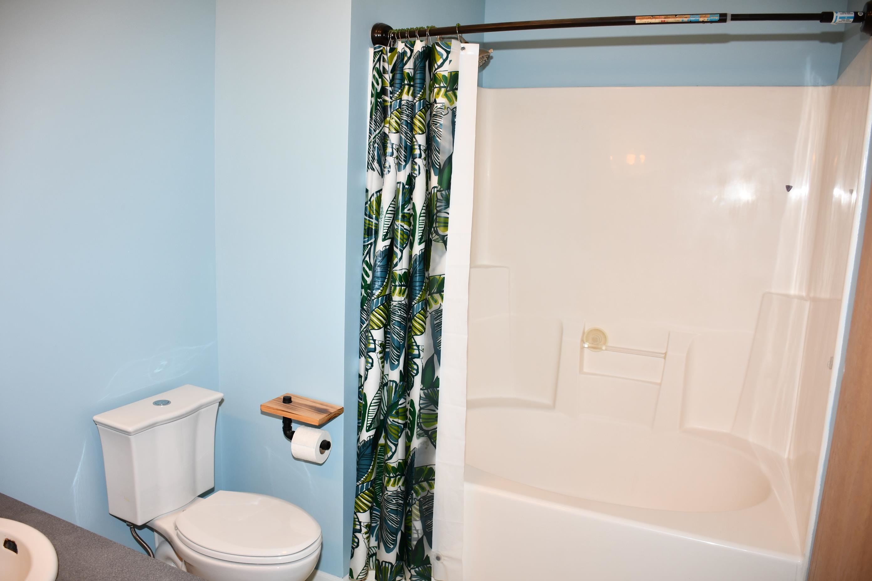 White shower-tub combination featuring integrated shelving