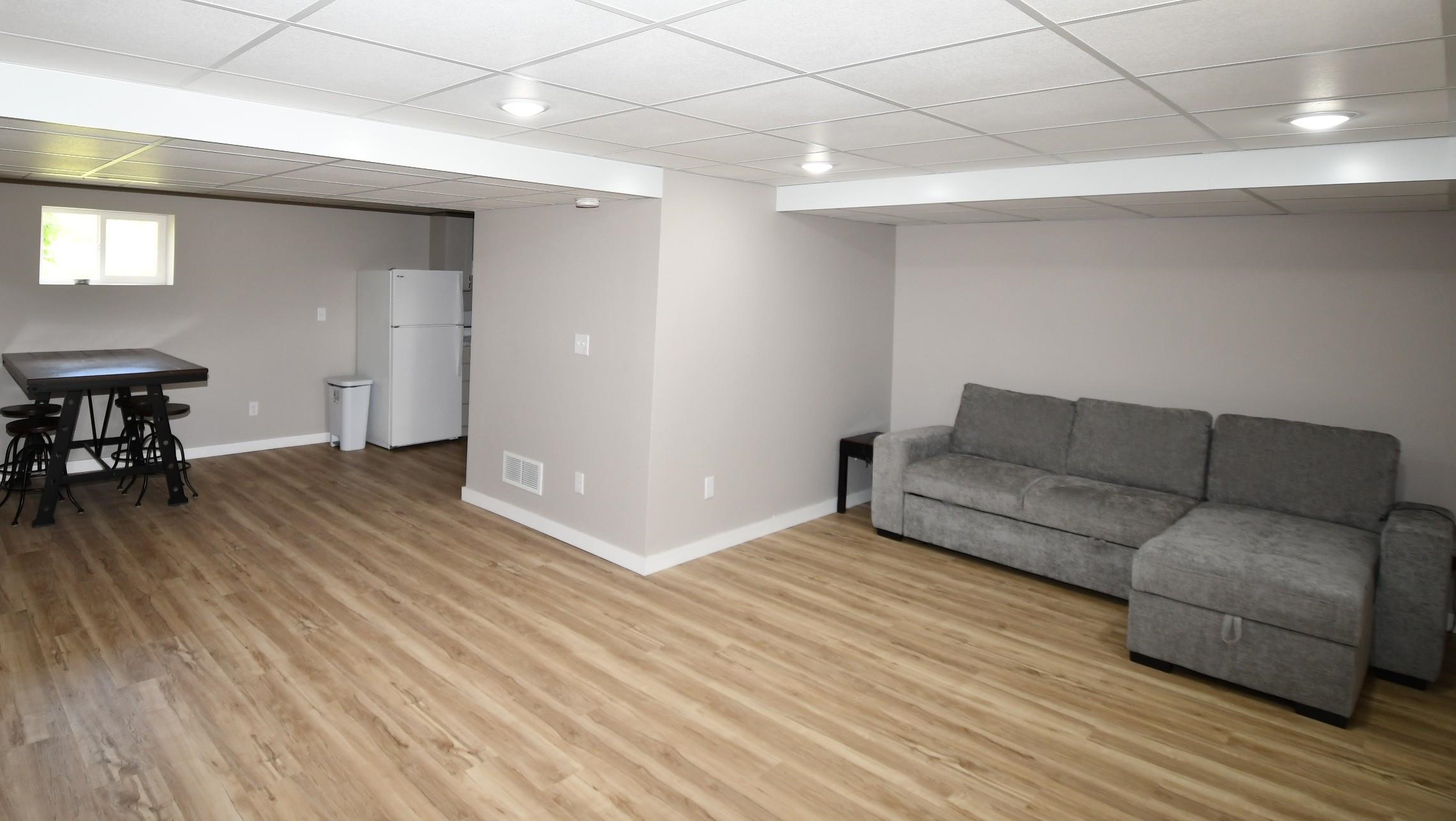 Finished basement space featuring light wood-finish flooring and neutral painted walls