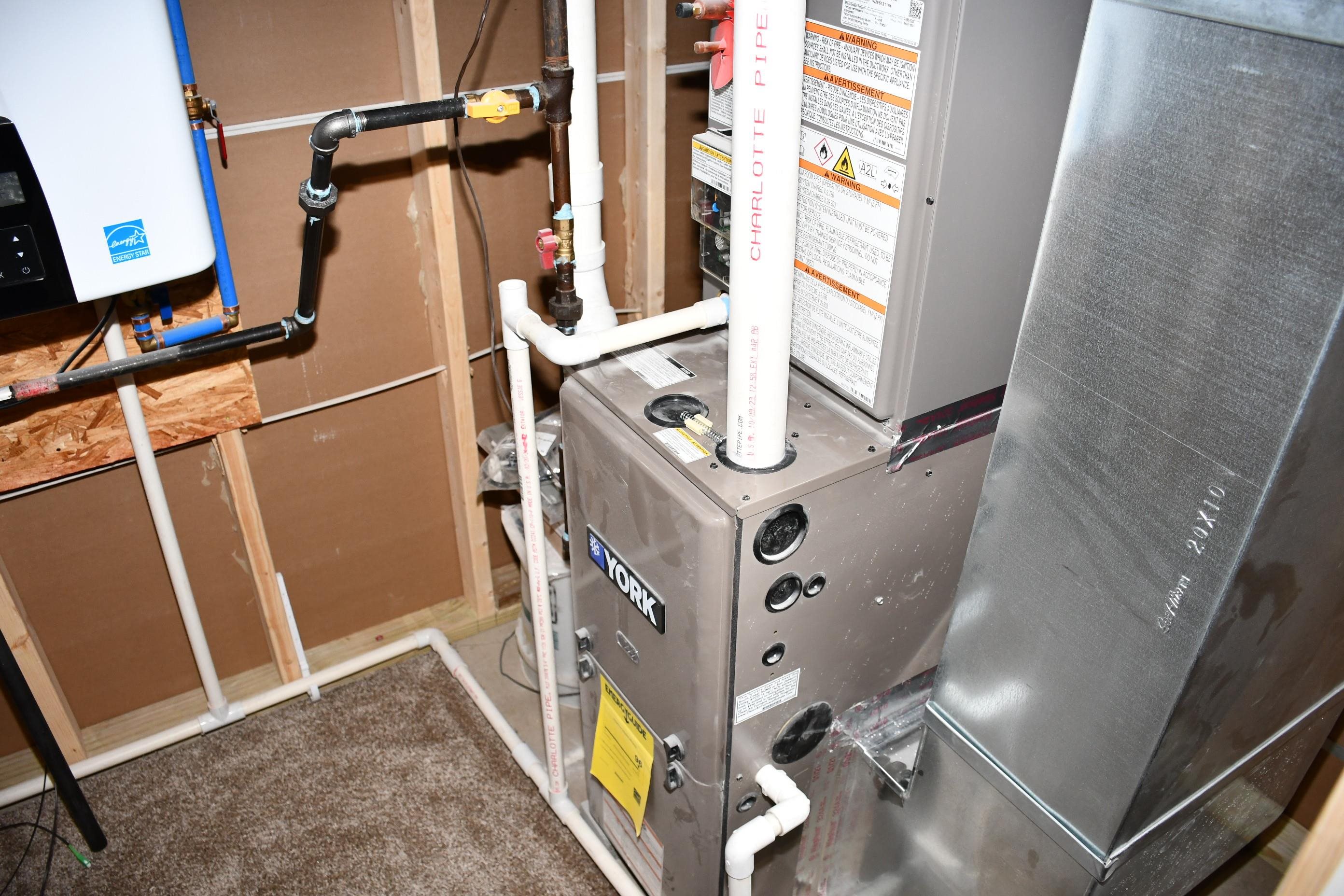 York furnace unit with extensive ductwork and a wall-mounted water heater