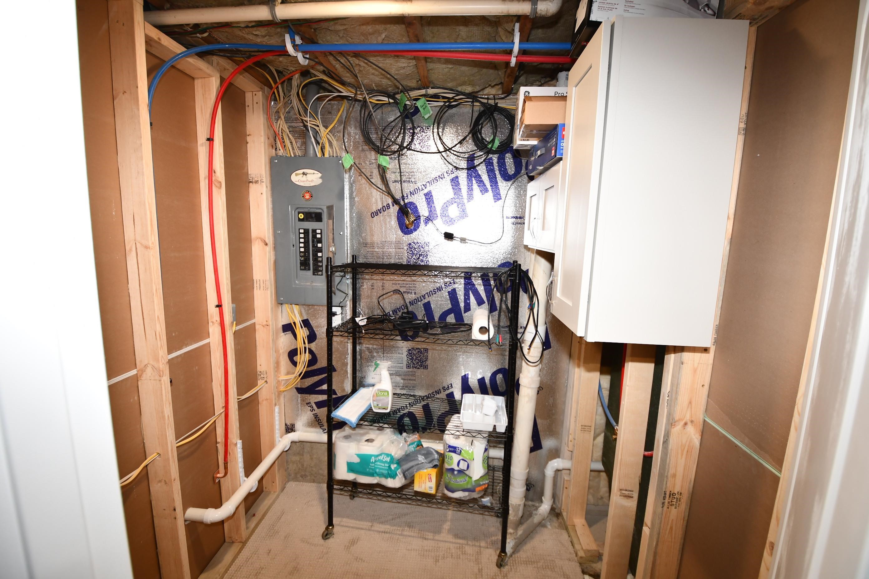 Utility area featuring exposed wood framing, a main electrical panel, and visible PEX plumbing