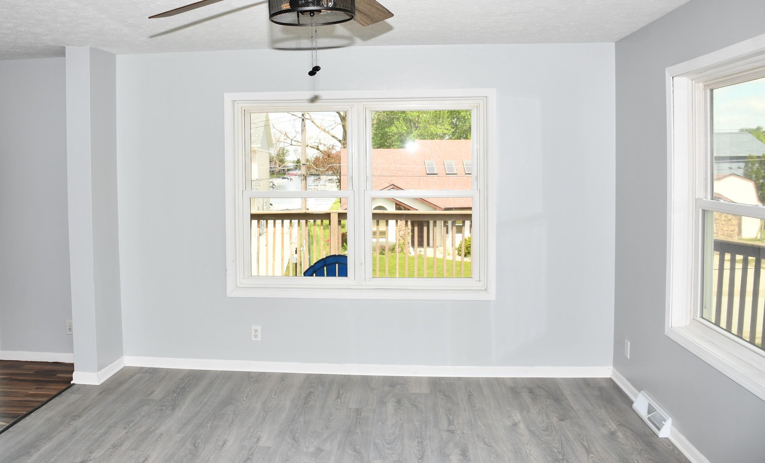Bright interior space featuring light gray wall paint and wood-finish flooring