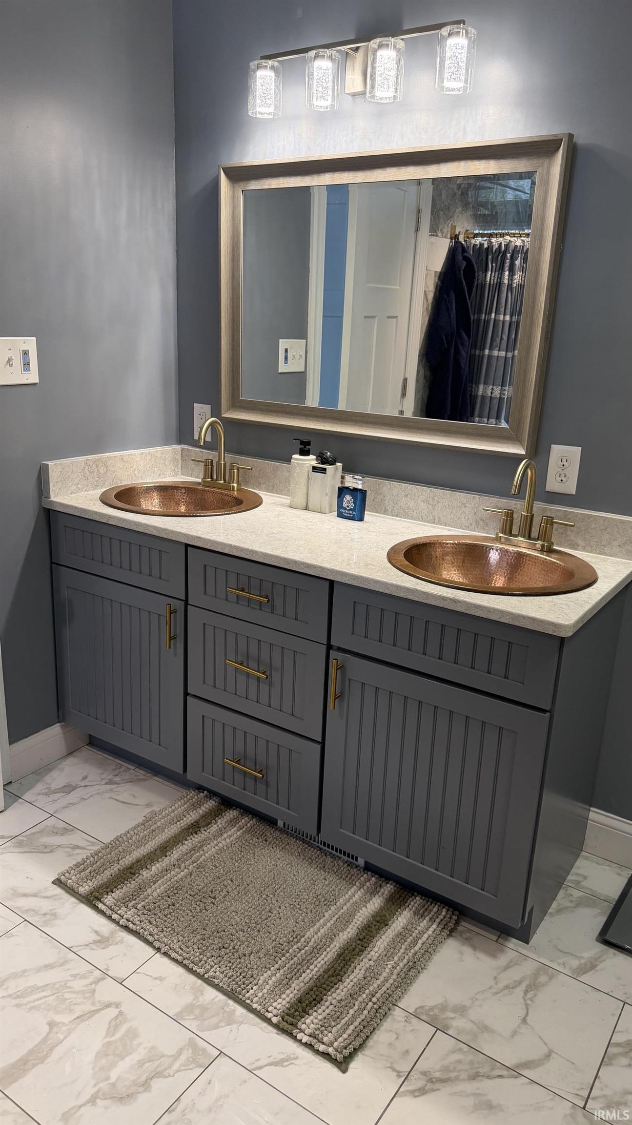 Double vanity with gray cabinetry, copper vessel sinks, and bronze-finish faucets