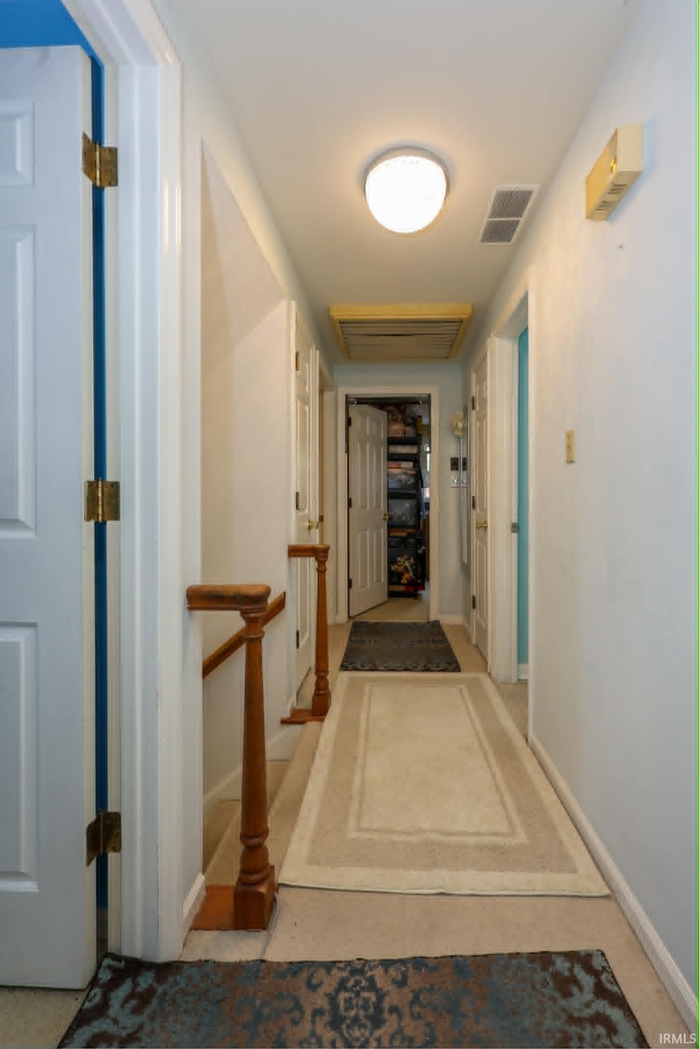 Hallway with neutral wall finishes and carpeted flooring