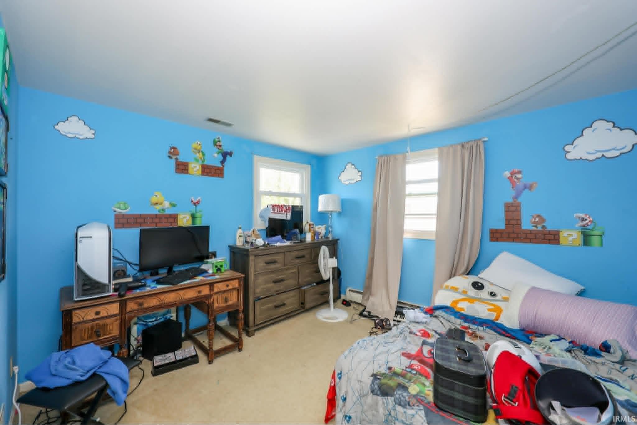 Carpeted room featuring light blue walls, two windows, and white trim