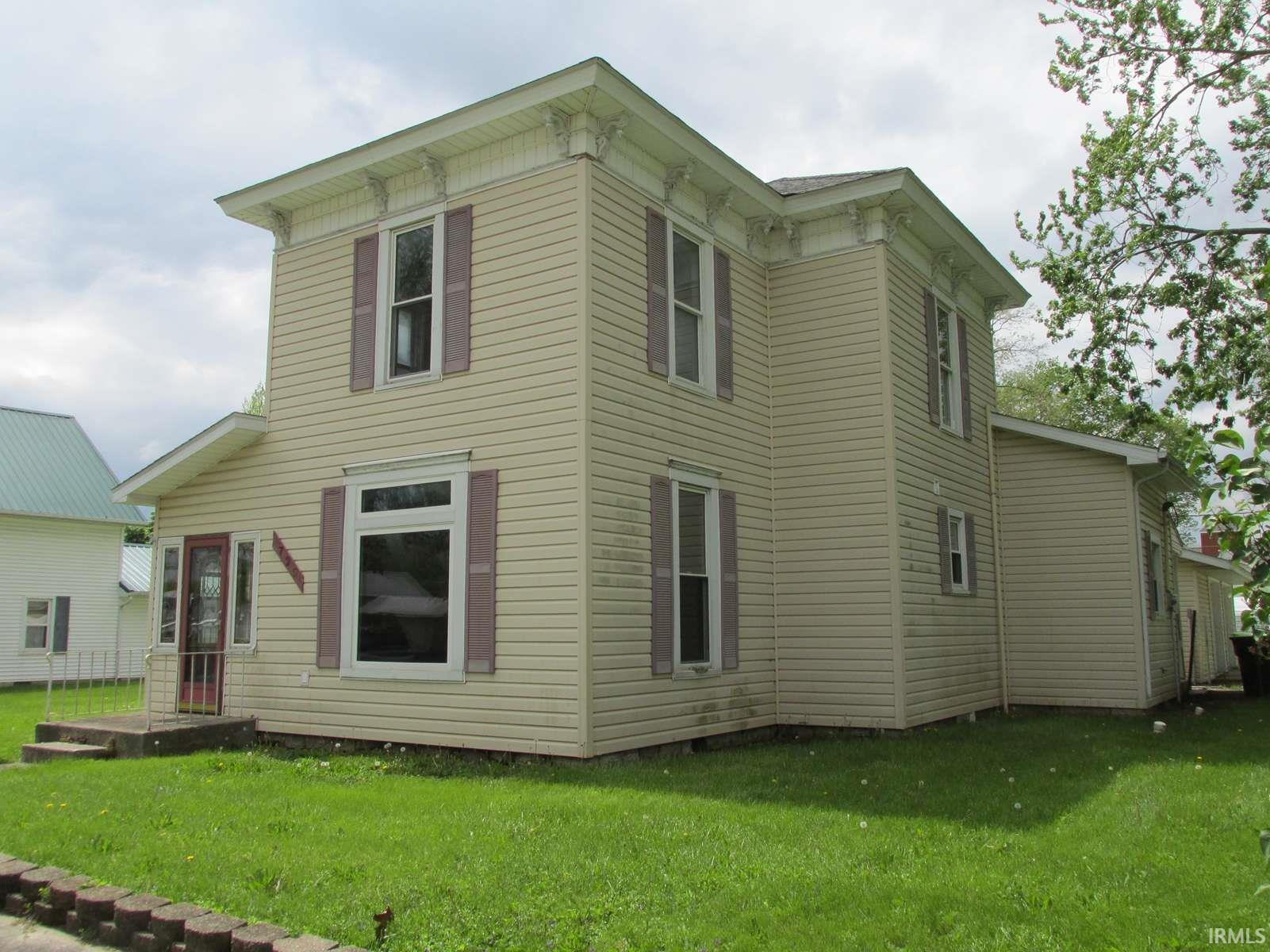 Two-story residence featuring light-colored siding and a contrasting trim