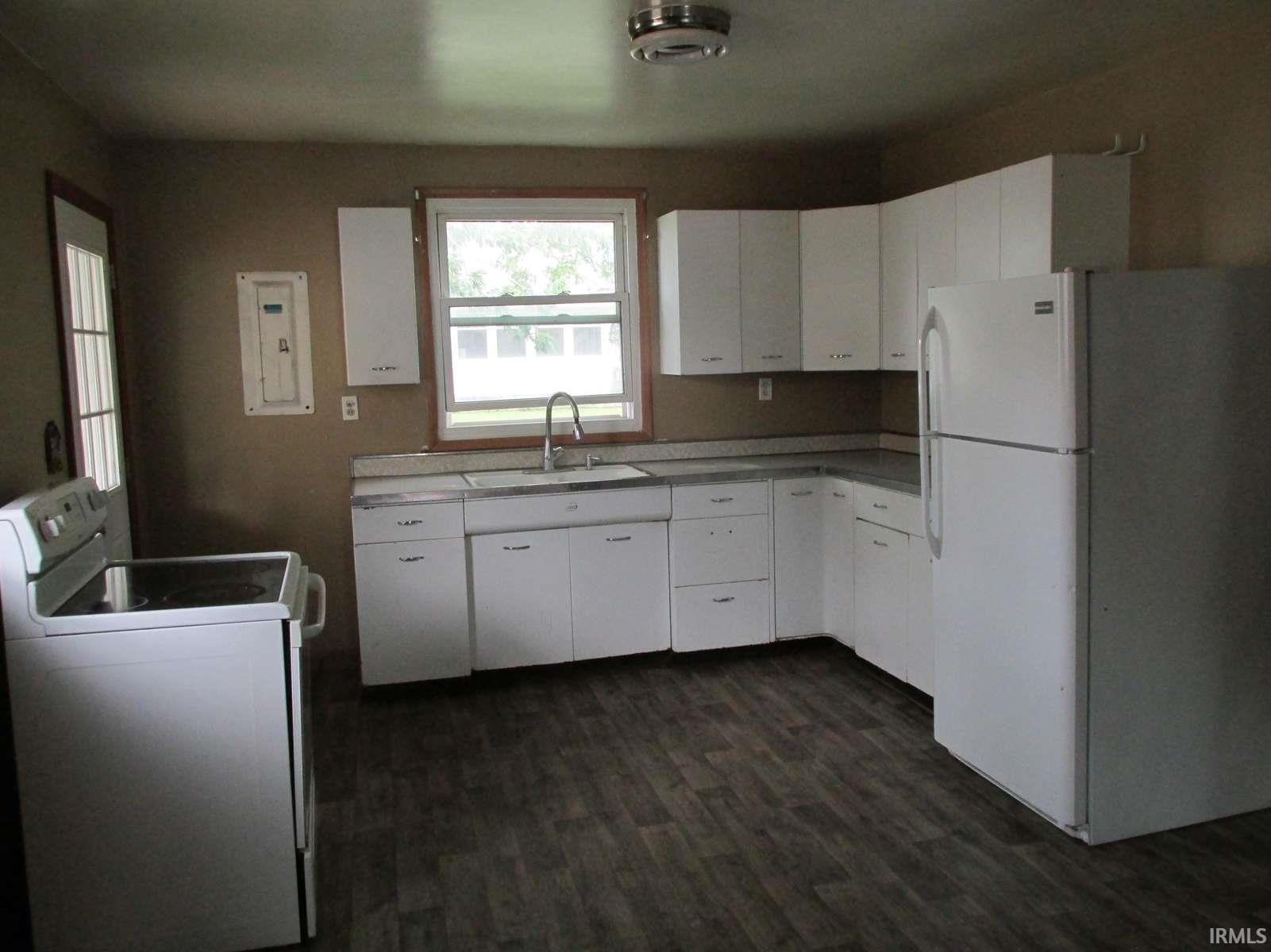 Kitchen featuring white cabinetry and appliances
