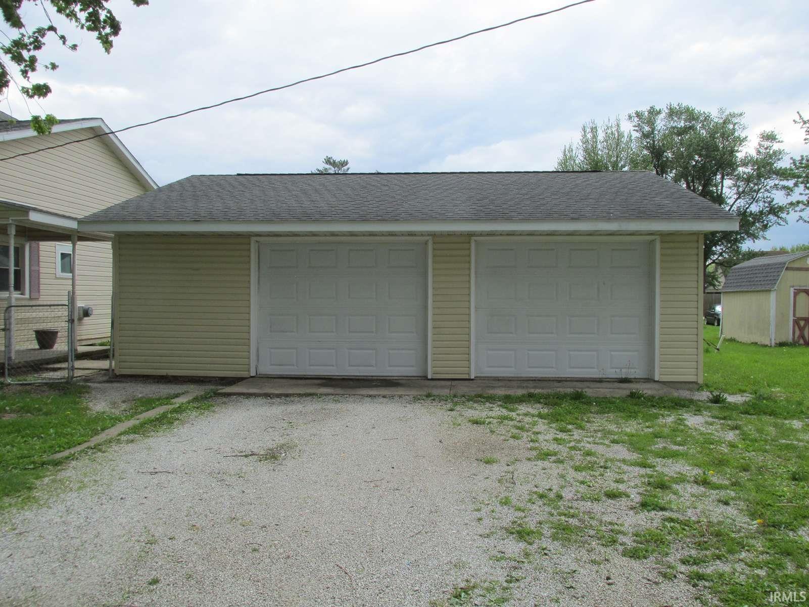 Two-car garage featuring panel-style doors and vinyl siding