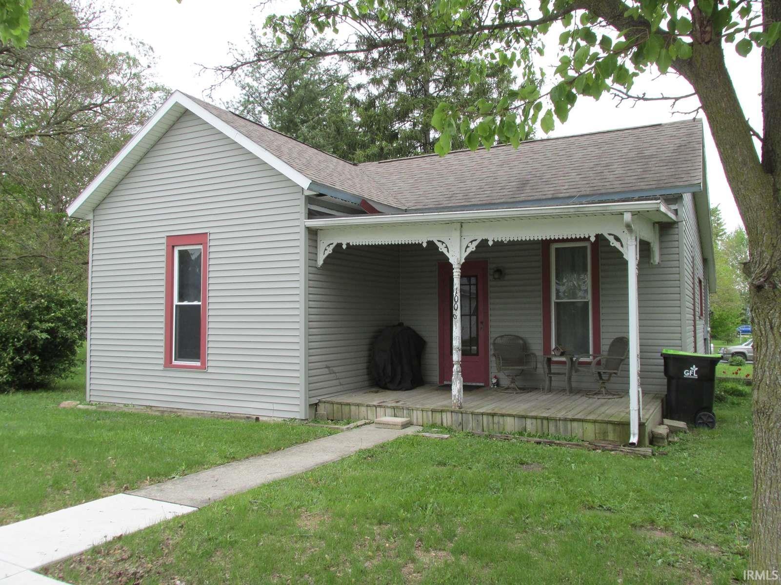 Single-story home featuring light gray siding with red trim accents
