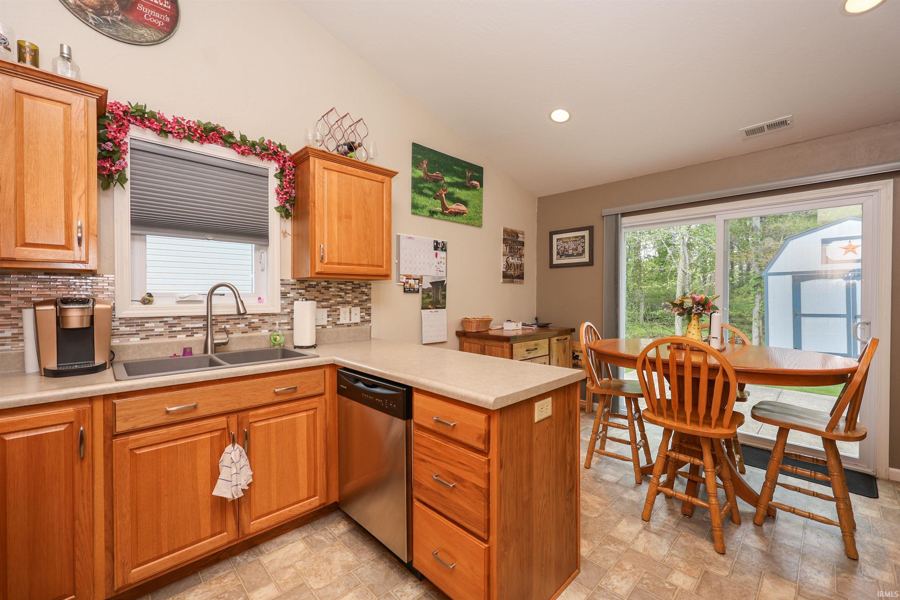 Kitchen featuring wood-finish cabinetry, solid surface countertops, and a mosaic tile backsplash