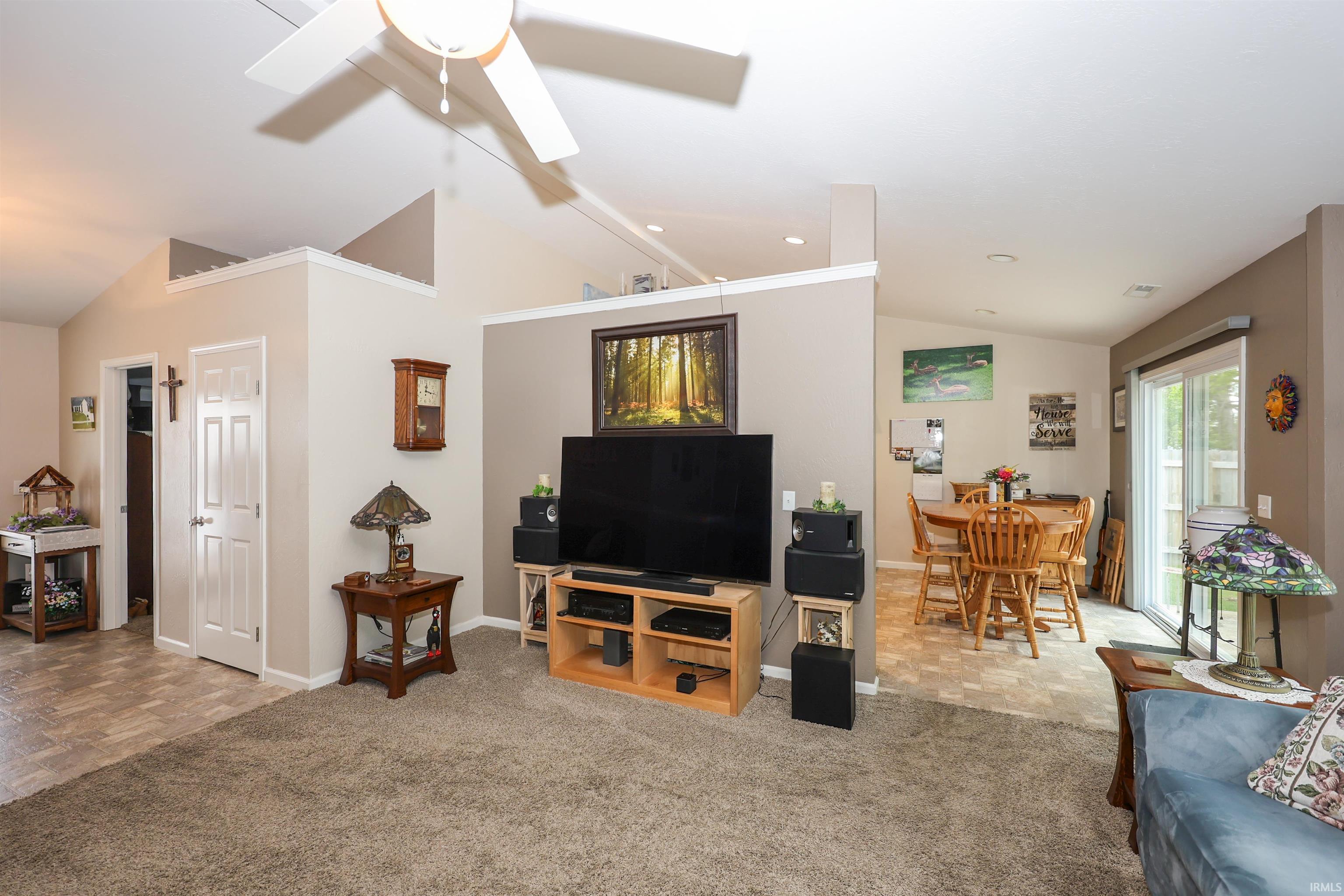 Open-concept living space featuring vaulted ceilings, a ceiling fan, and recessed lighting