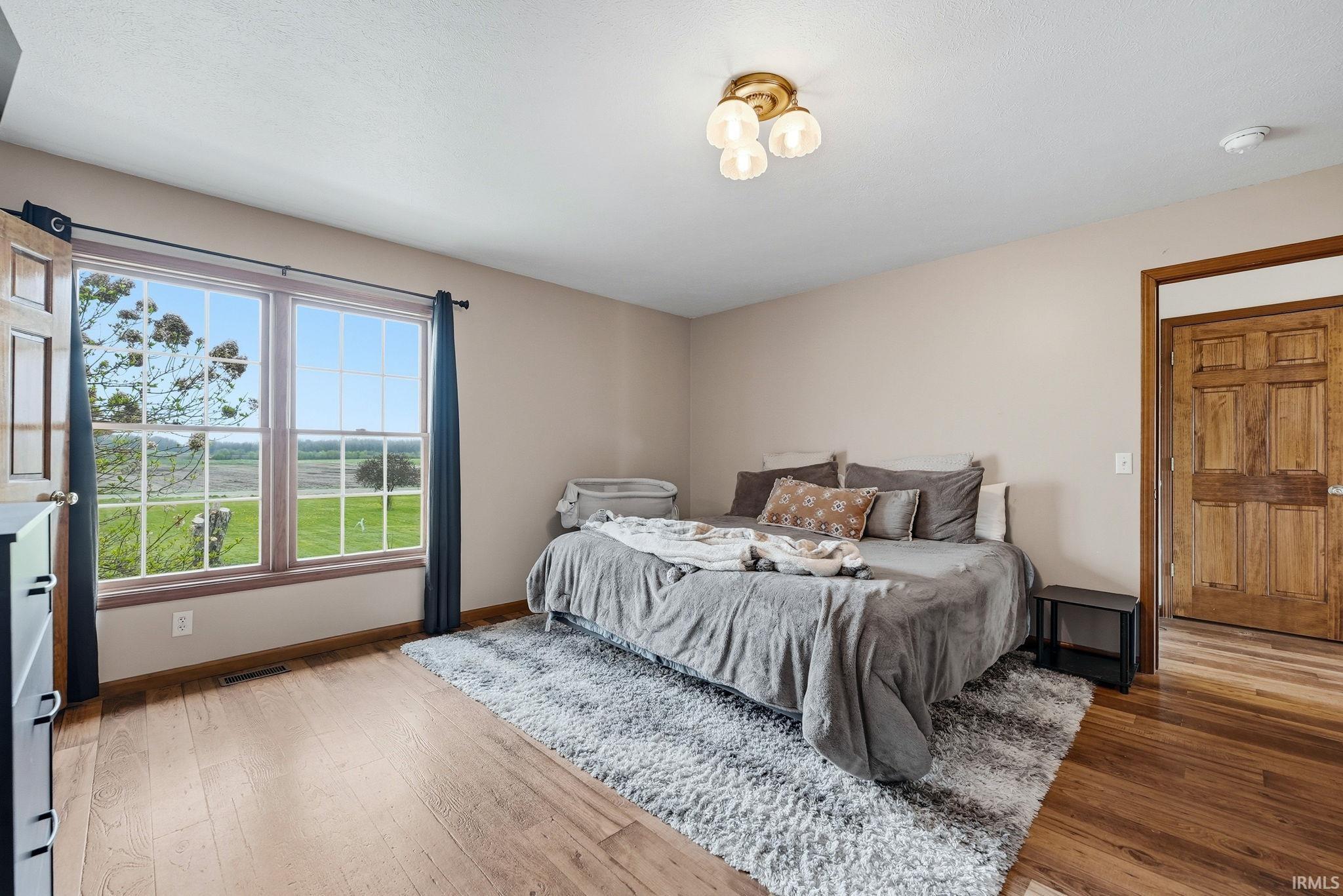 Bright bedroom with wood-finish flooring and neutral wall tones