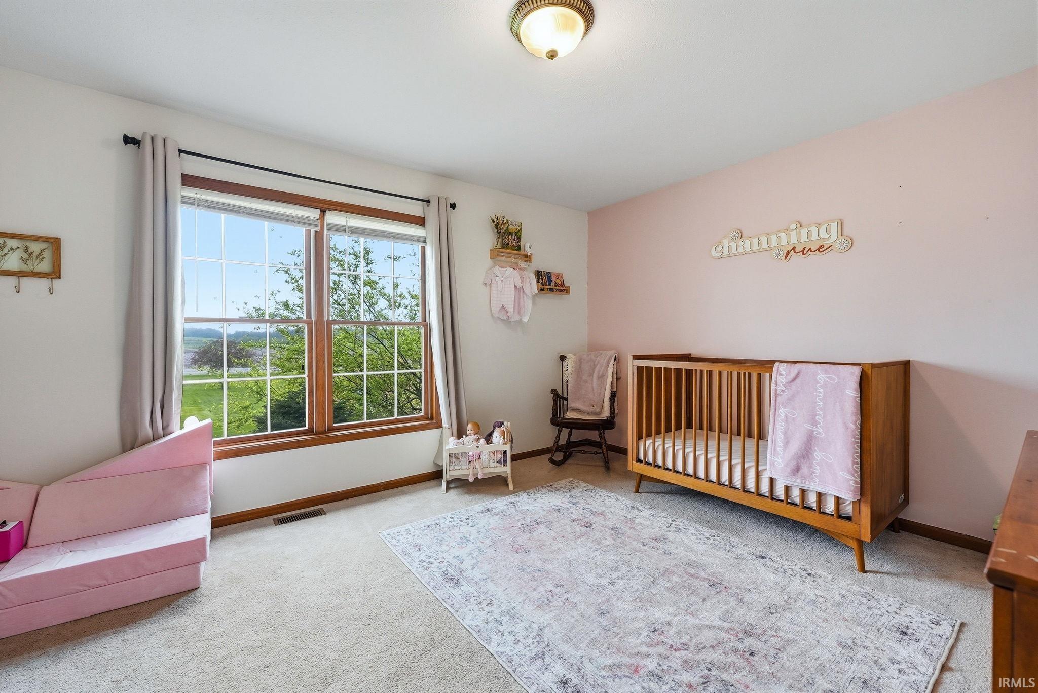 Wall-to-wall carpeting and a large window with wood trim