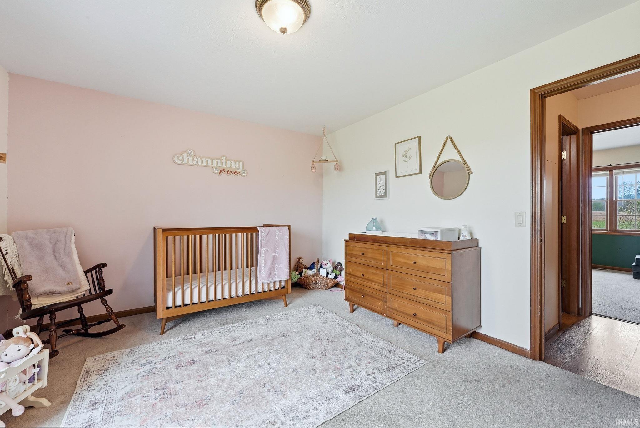 Carpeted room featuring light-colored walls and a wood-finish doorway
