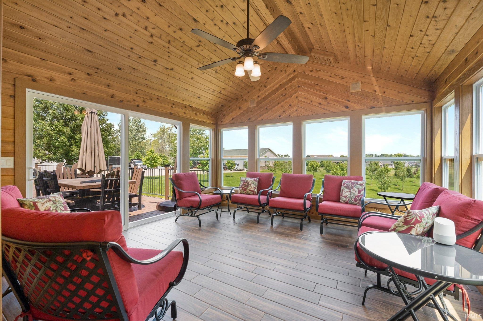 Sunroom with wood-finish vaulted ceilings and a ceiling fan with integrated lighting