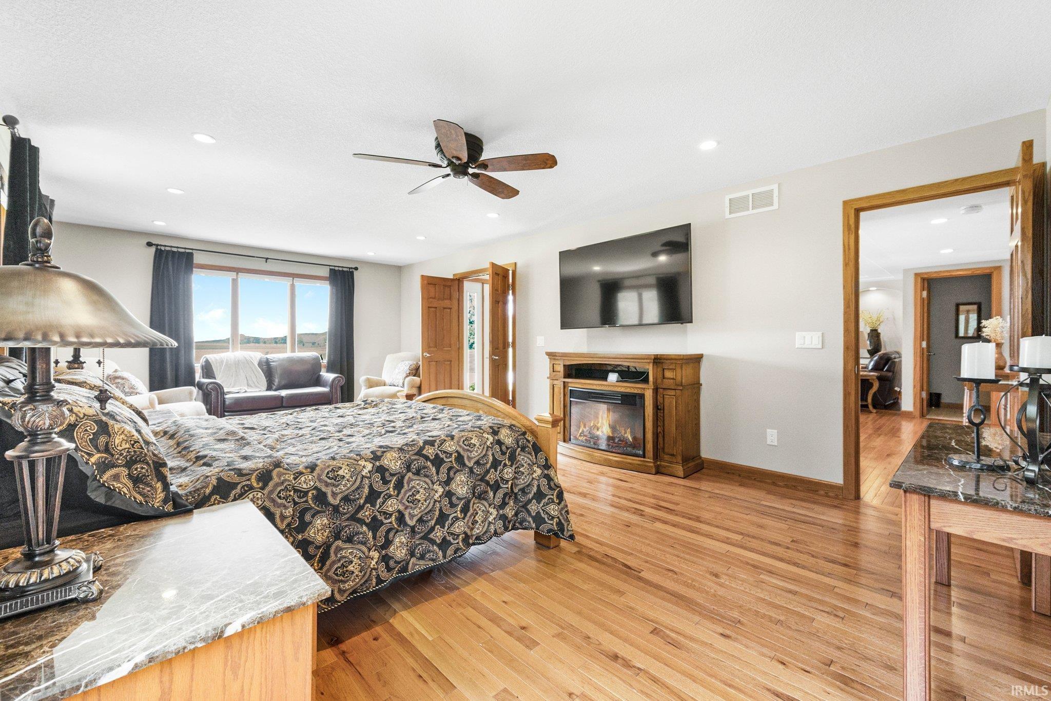 Spacious room featuring wood-finish flooring and recessed lighting