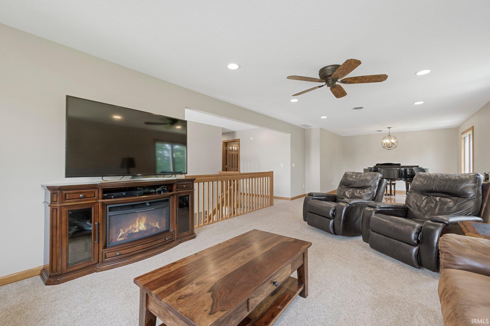 Spacious living area featuring neutral carpeting and recessed lighting