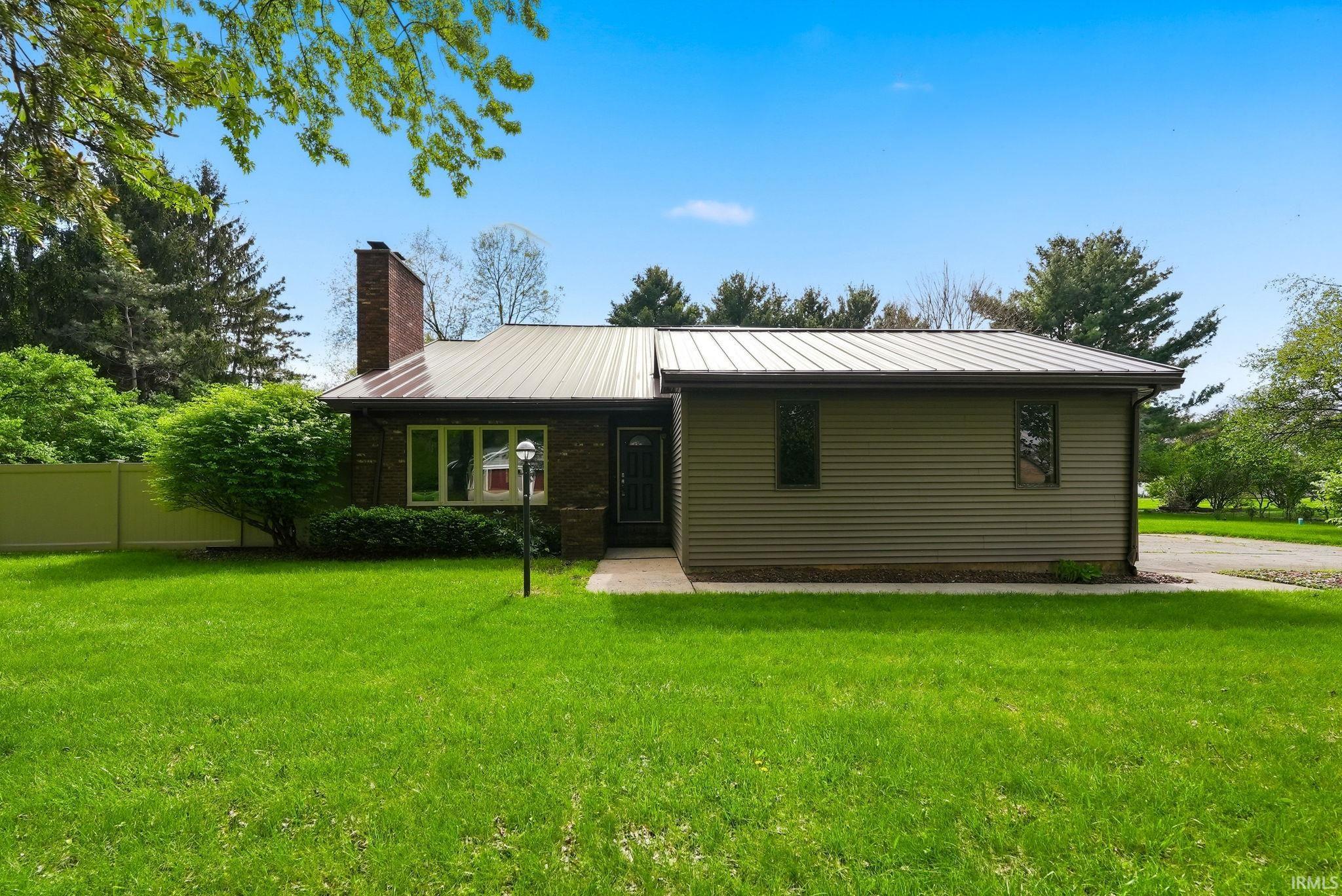 Exterior featuring a metal roof, brick facade, and horizontal siding