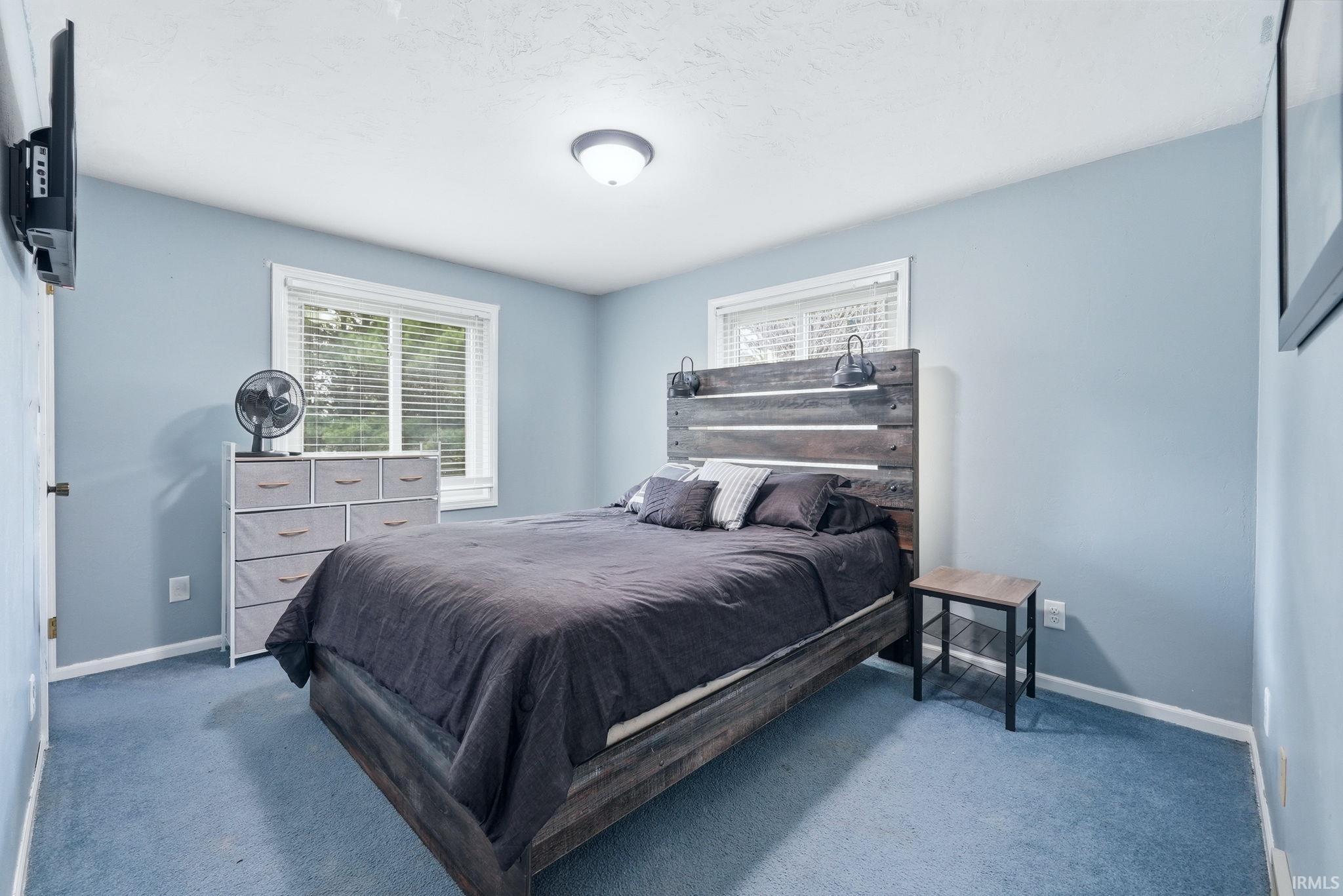 Bedroom featuring light blue walls and blue carpeting