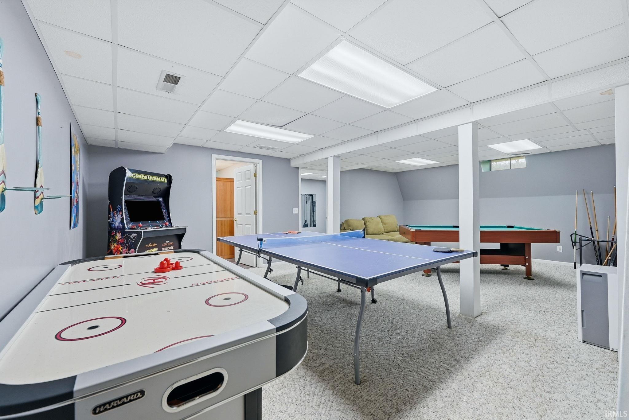 Expansive recreational space featuring light gray walls and carpet flooring