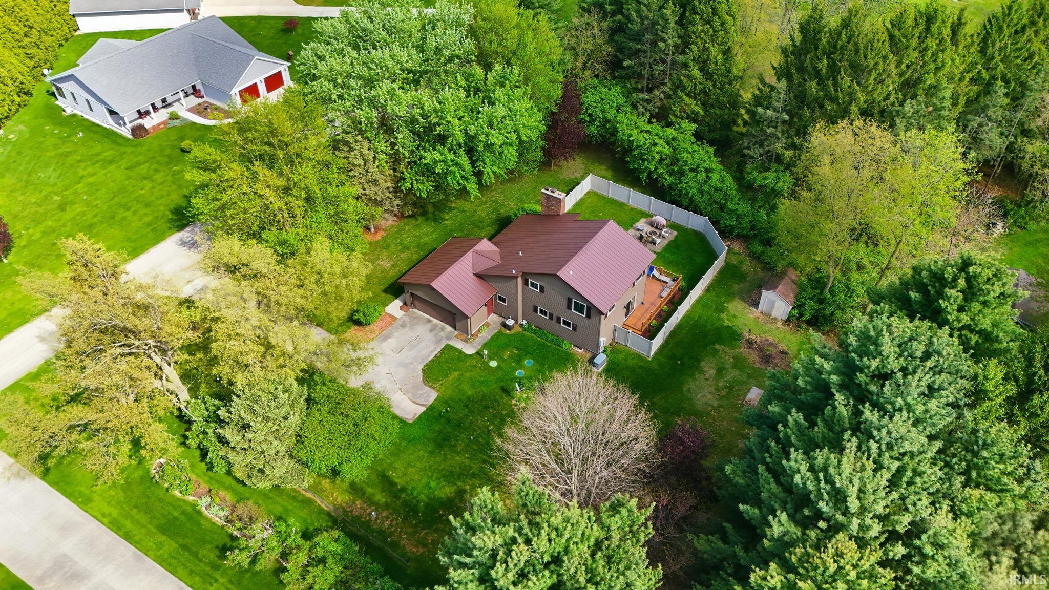 Property featuring a reddish-brown metal roof, an attached garage, and a rear deck